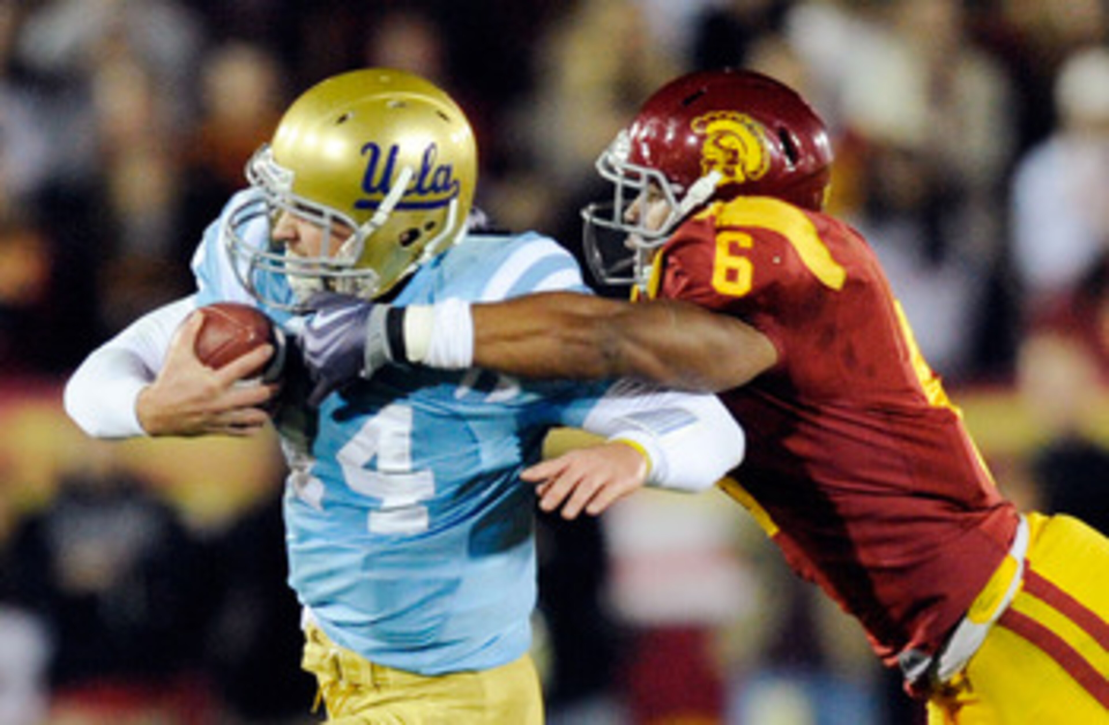 LOS ANGELES, CA - NOVEMBER 28:  Quarterback Kevin Prince #14 of the UCLA Bruins is tackled by Malcolm Smith #6 of the USC Trojans during the second quarter of the NCAA college football game at Los Angeles Memorial Coliseum on November 28, 2009 in Los Ange