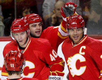 CALGARY, CANADA - APRIL 6:Jarome Iginla #12 of the Calgary Flames is congratulated by teammates Alex Tanguay #40 and Mark Giordano #5 on his hat trick goal against the Edmonton Oilers in third period NHL action on April 6, 2011 at the Scotiabank Saddledom