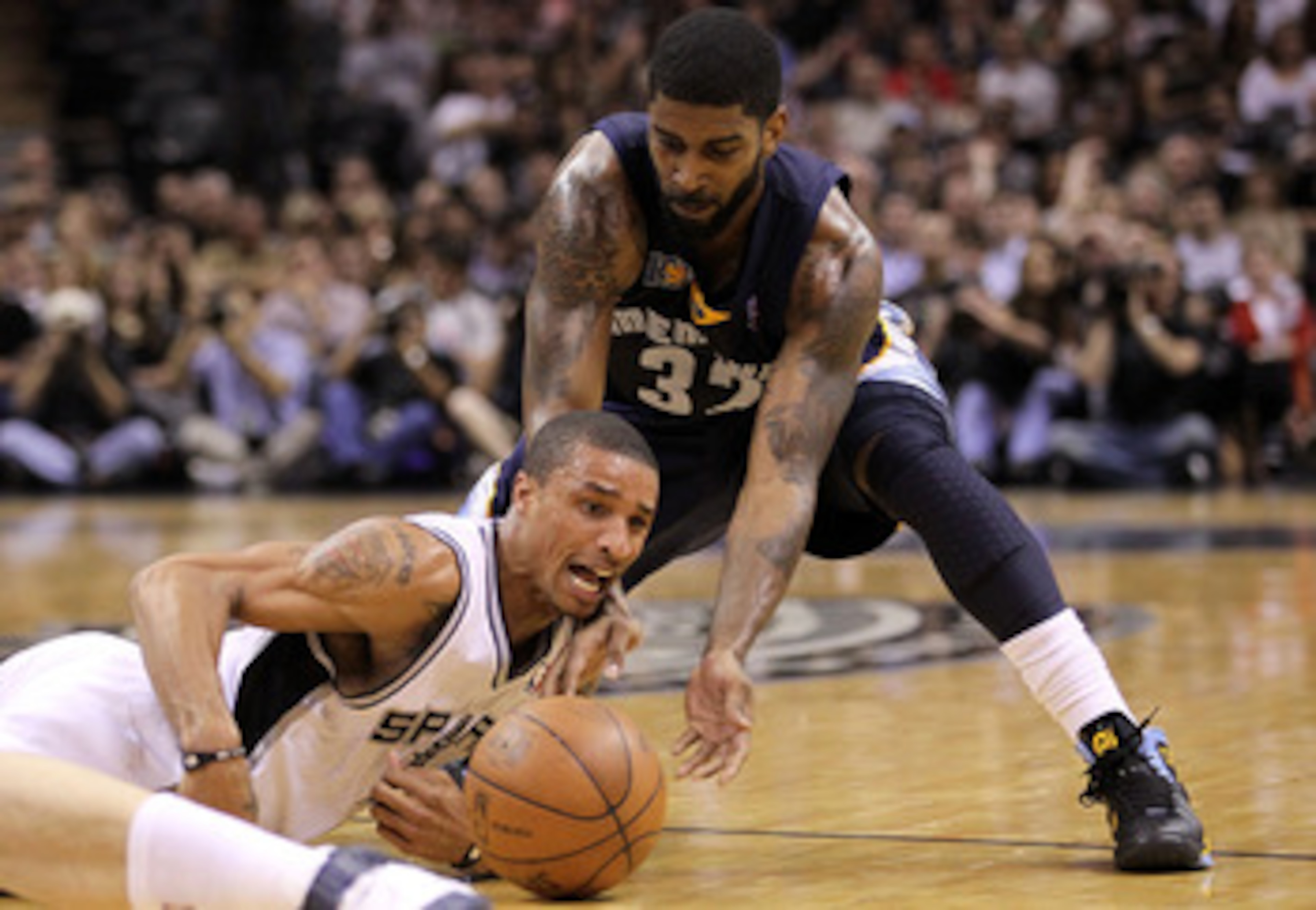 SAN ANTONIO, TX - APRIL 20:  Guard George Hill #3 of the San Antonio Spurs falls for the loose ball against O.J. Mayo #32 of the Memphis Grizzlies in Game Two of the Western Conference Quarterfinals in the 2011 NBA Playoffs on April 20, 2011 at AT&T Cente
