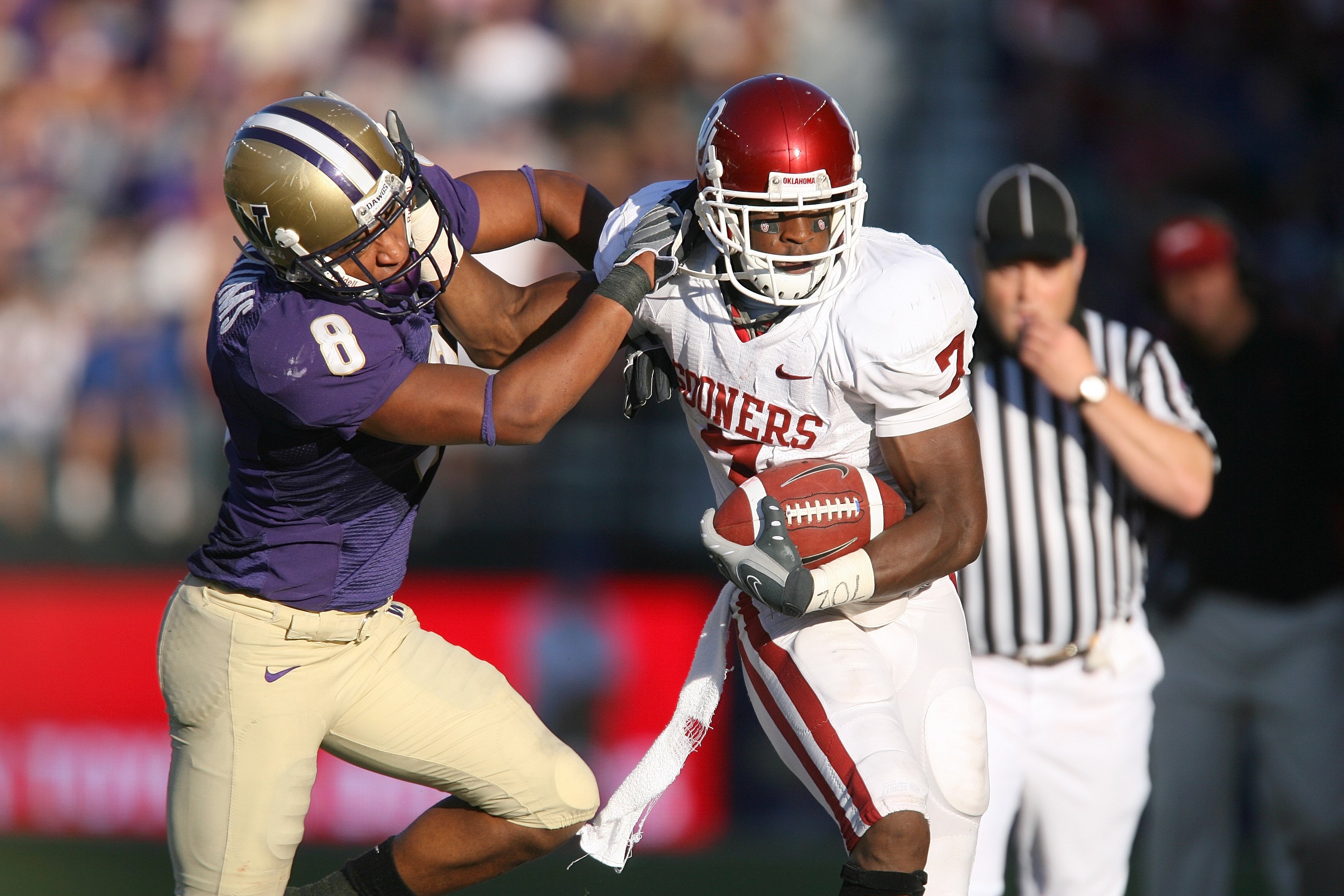 SEATTLE - SEPTEMBER 13:  Running back DeMarco Murray #7 of the Oklahoma Sooners runs with the ball against Nate Williams #8 of the Washington Huskies during the game on September 13, 2008 at Husky Stadium in Seattle, Washington. The Sooners defeated the H