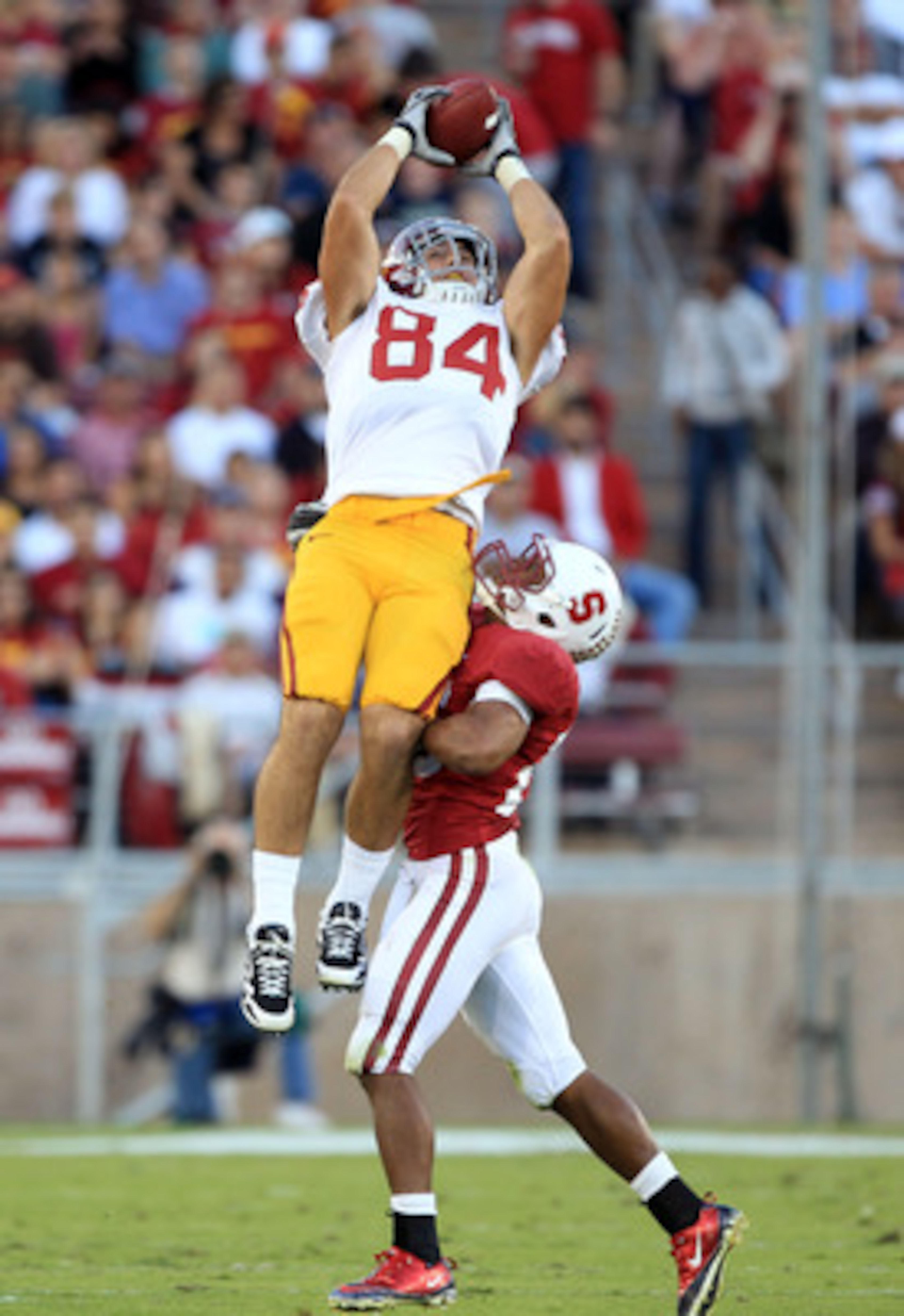 PALO ALTO, CA - OCTOBER 09:  Jordan Cameron #84 of the USC Trojans leaps to catch a ball over Delano Howell #26 of the Stanford Cardinal at Stanford Stadium on October 9, 2010 in Palo Alto, California. Cameron lost control of the ball on the way back down