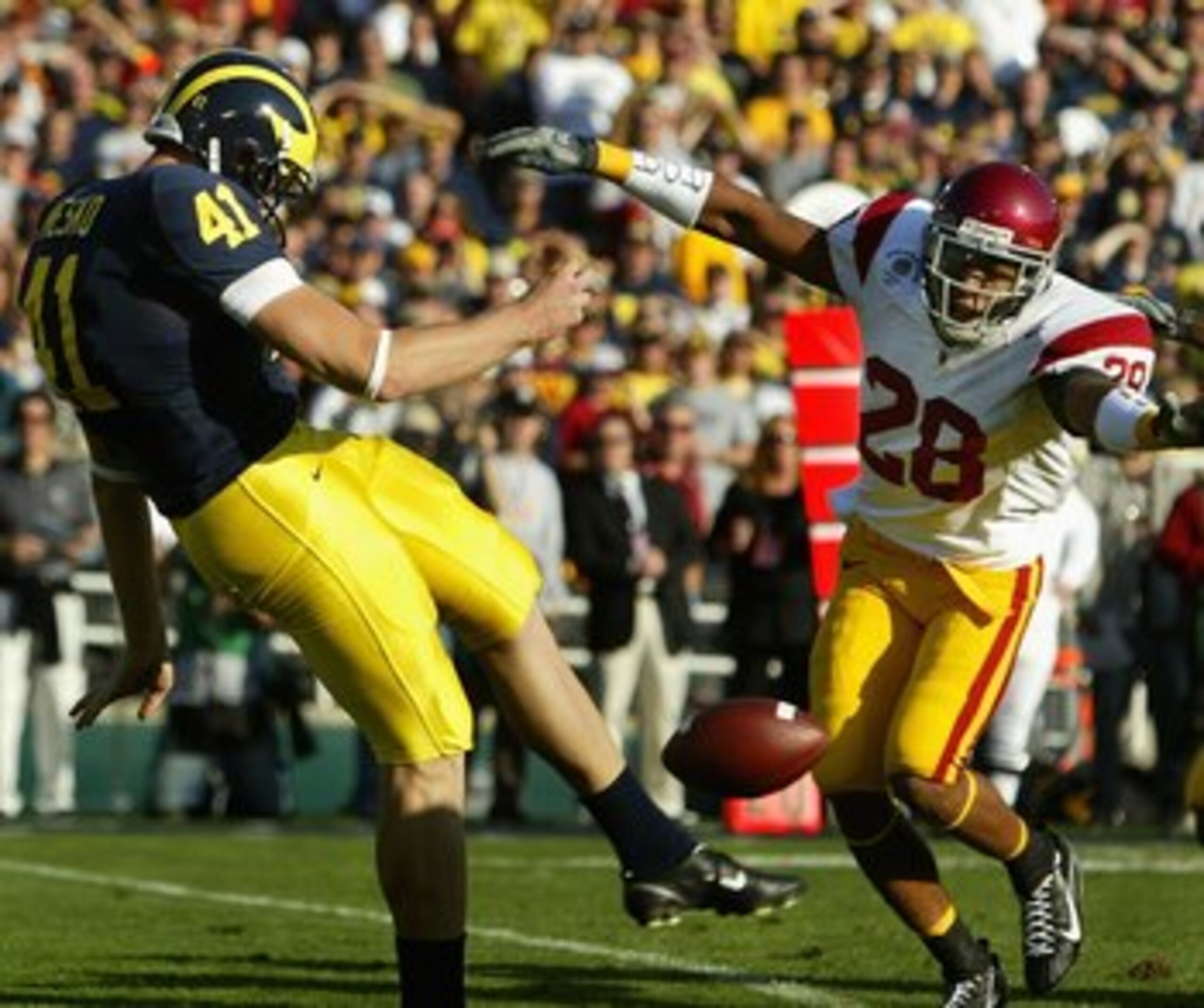 PASADENA, CA - JANUARY 01:  Punter Zoltan Mesko #41 of the Michigan Wolverines punts the ball under pressure from Terrell Thomas #28 and Cary Harris #7 of the USC Trojans during the Rose Bowl game on January 1, 2007 at the Rose Bowl in Pasadena, Californi