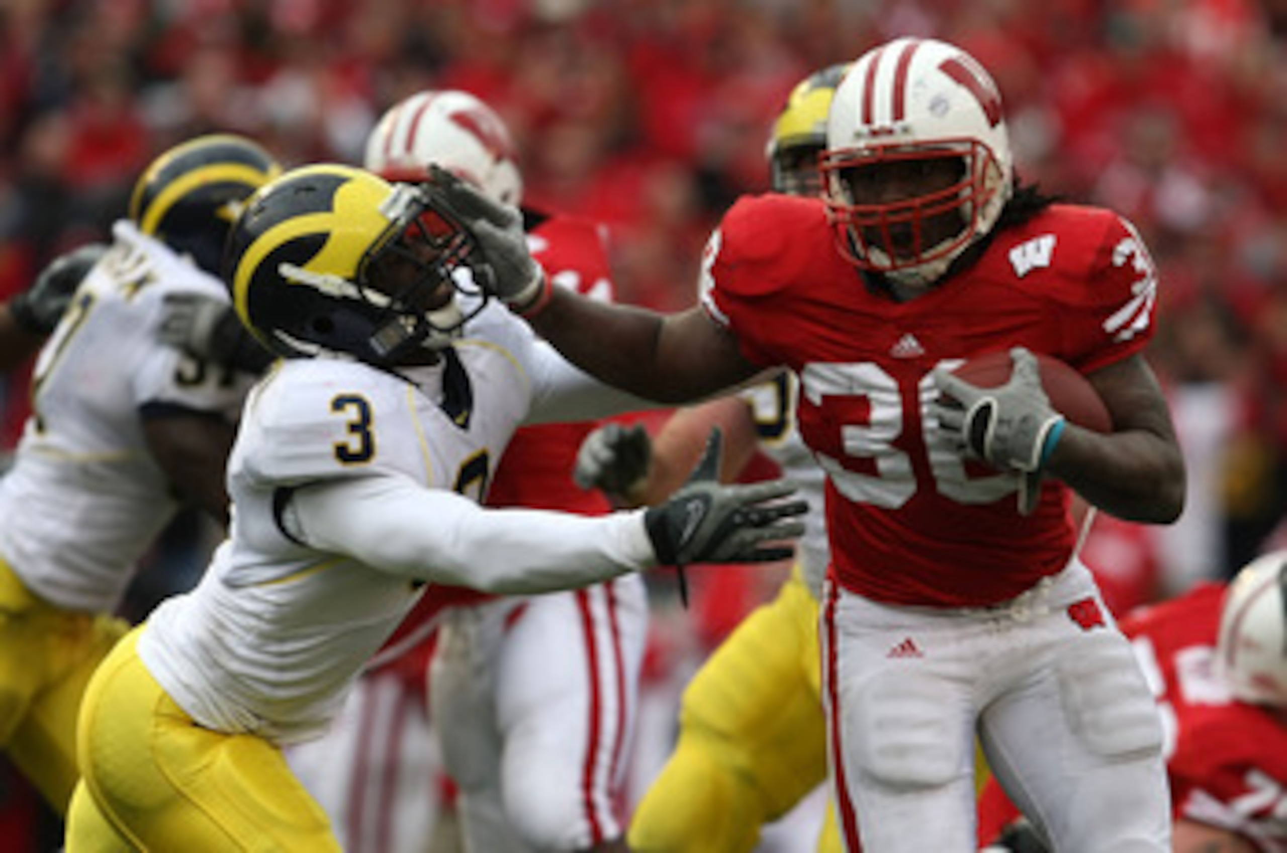 MADISON, WI - NOVEMBER 10: Zach Brown #30 of the Wisconsin Badgers pushes off Stevie Brown #3 of the Michigan Wolverines on November 10, 2007 at Camp Randall Stadium in Madison, Wisconsin. Wisconsin defeated Michigan 37-21.  (Photo by Jonathan Daniel/Gett