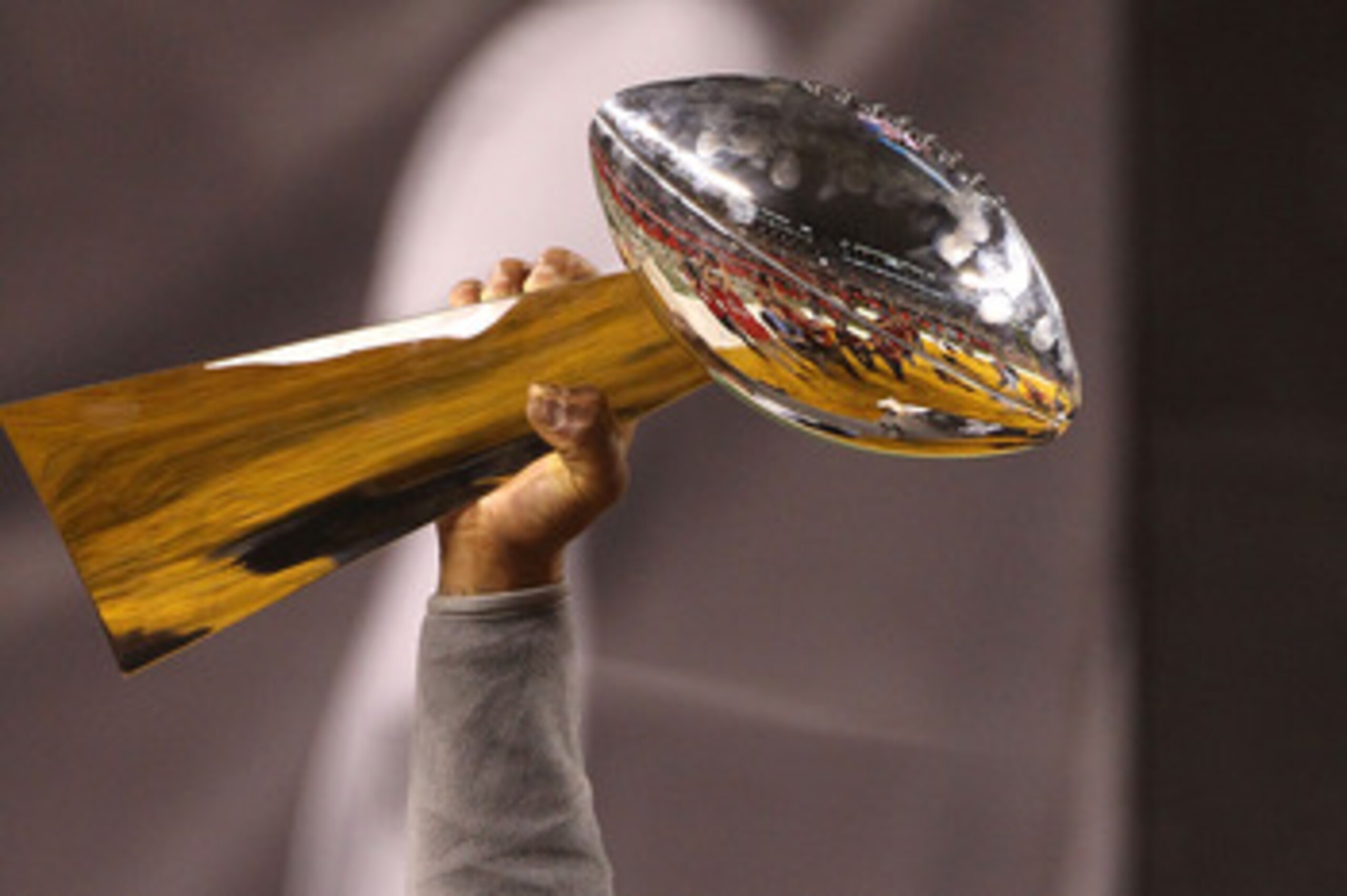ARLINGTON, TX - FEBRUARY 06:  Charles Woodson #21 of the Green Bay Packers holds up the Lombardi Trophy after winning Super Bowl XLV 31-25 against the Pittsburgh Steelers at Cowboys Stadium on February 6, 2011 in Arlington, Texas. Woodson left the game wi