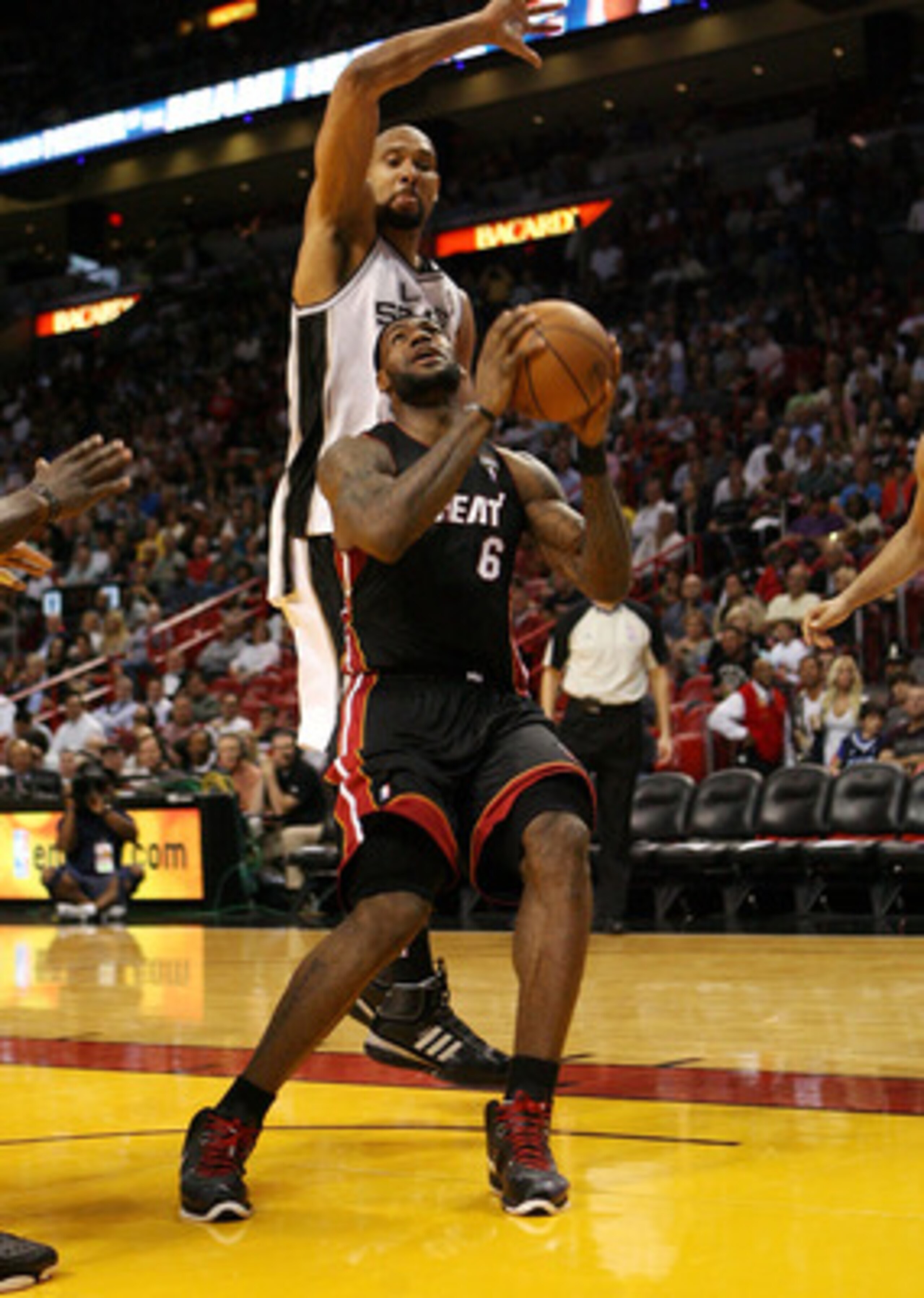 MIAMI - MARCH 14:  Forward LeBron James #6 of the Miami Heat drives against Center Tim Duncan #21 of the San Antonio Spurs at American Airlines Arena on March 14, 2011 in Miami, Florida. The Heat defeated the Spurs 110-80. NOTE TO USER: User expressly ack