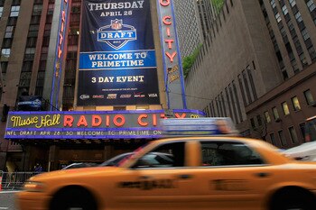 NEW YORK, NY - APRIL 28:  Taxi cabs drive down the Avenue of the Americas past the Radio City Music Hall marquee, site of the 2011 NFL Draft, on April 28, 2011 in New York City.  (Photo by Chris Trotman/Getty Images)