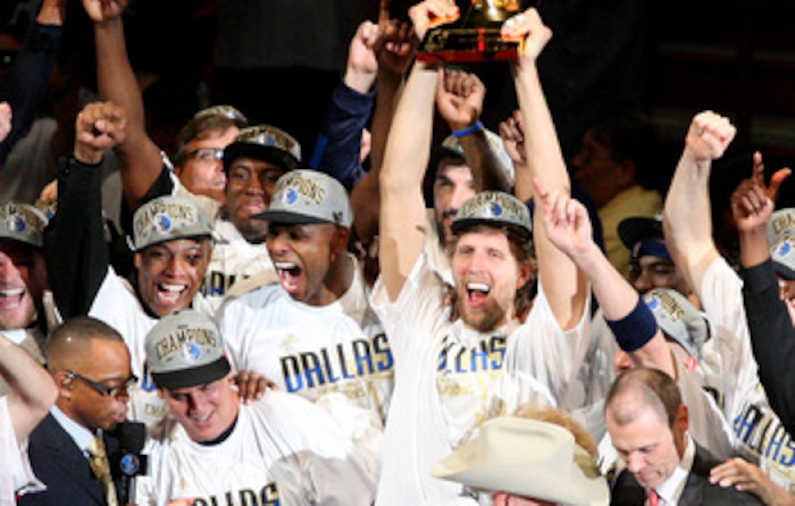 MIAMI, FL - JUNE 12:  Dirk Nowitzki #41 of the Dallas Mavericks holds up the Larry O'Brien trophy as he celebrates with his teamates and team owner Mark Cuban aftre the Mavericks won 105-95 against the Miami Heat in Game Six of the 2011 NBA Finals at Amer
