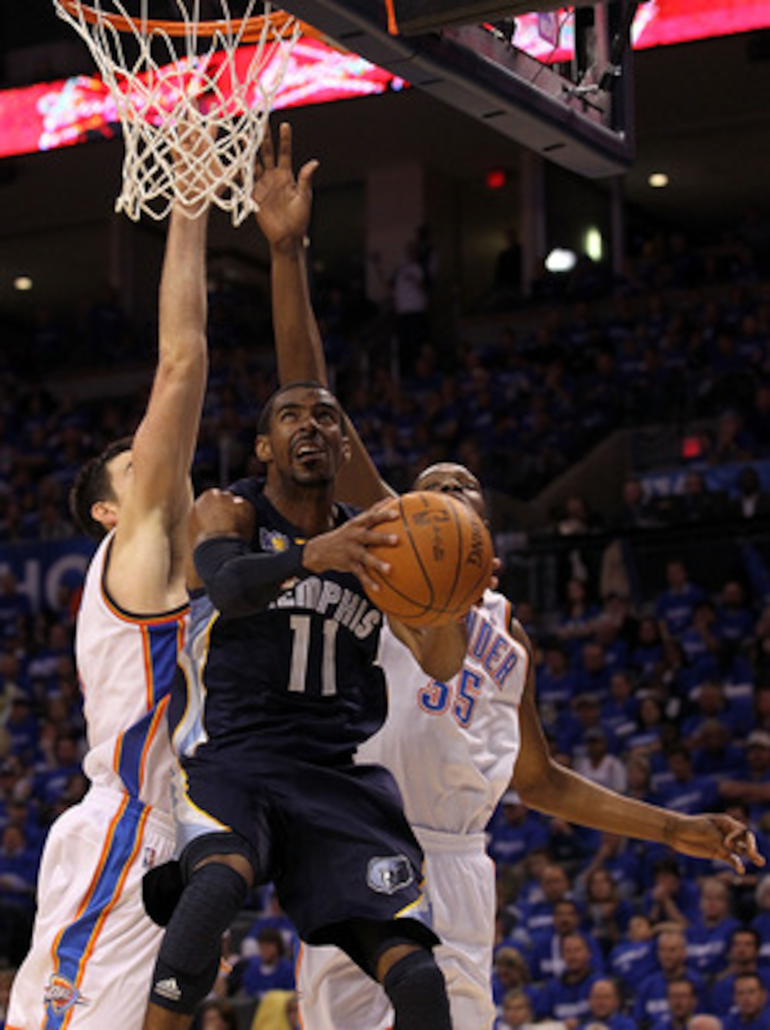 OKLAHOMA CITY, OK - MAY 01:  Guard Mike Conley #11 of the Memphis Grizzlies takes a shot against Nick Collison #4 and Kevin Durant #35 of the Okalhoma City Thunder in Game One of the Western Conference Semifinals in the 2011 NBA Playoffs on May 1, 2011 at