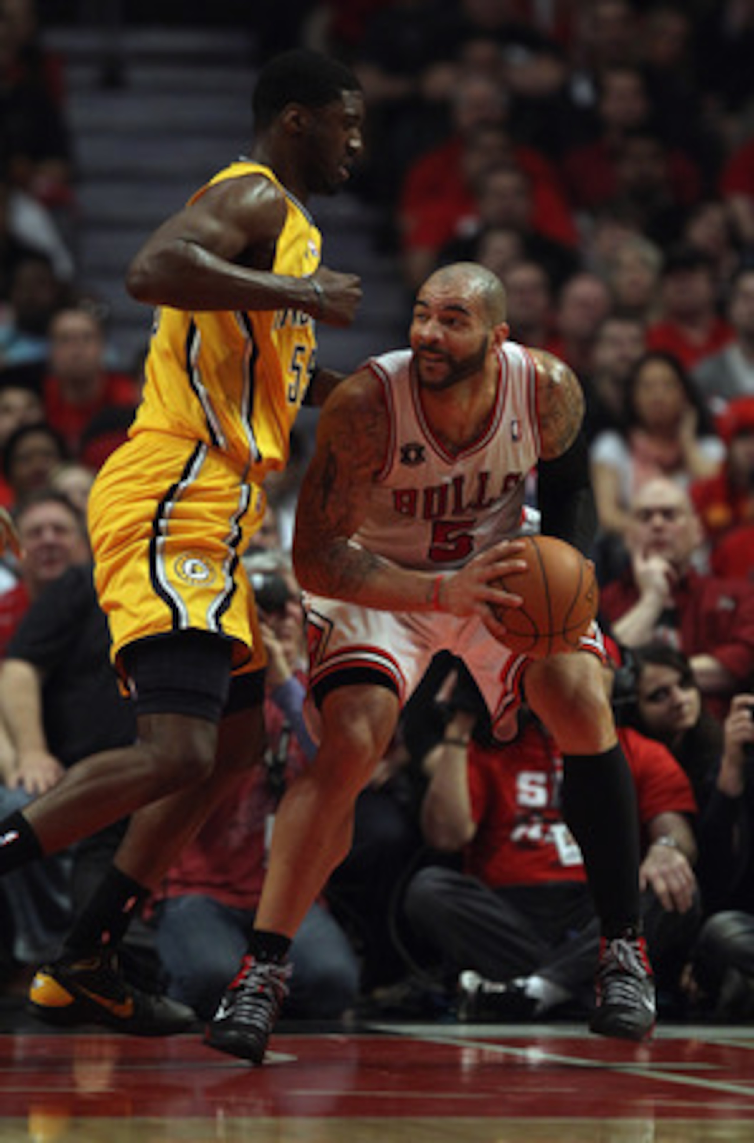 CHICAGO, IL - APRIL 26: Carlos Boozer #5 of the Chicago Bulls moves against Roy Hibbert #55 of the Indiana Pacers in Game Five of the Eastern Conference Quarterfinals in the 2011 NBA Playoffs at the United Center on April 26, 2011 in Chicago, Illinois. Th