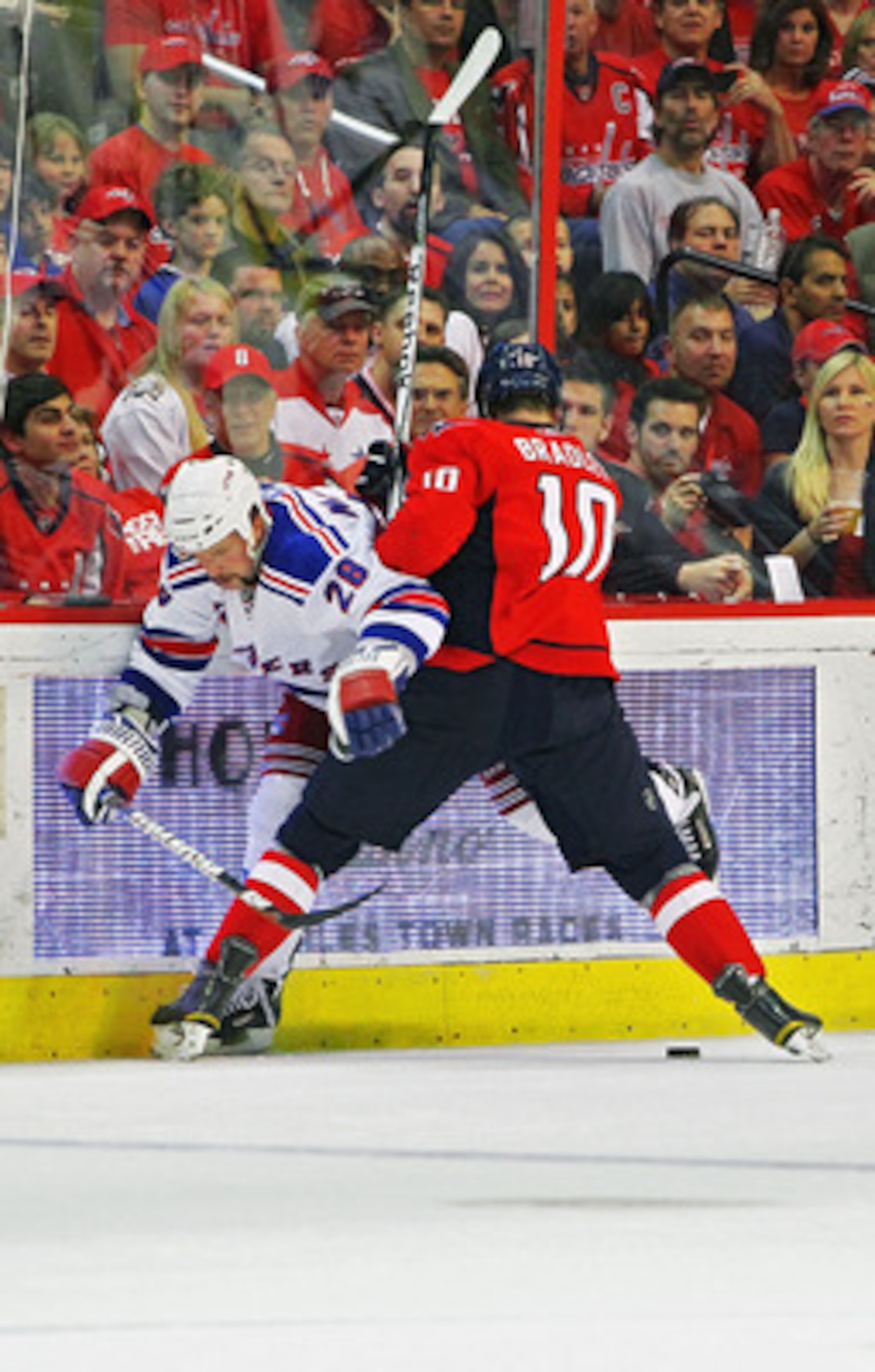 WASHINGTON , DC - APRIL 23: Matt Bradley #10 of the Washington Capitals battles for the puck as he checks Bryan McCabe #28 of the New York Rangers in Game Five of the Eastern Conference Quarterfinals during the 2011 NHL Stanley Cup Playoffs at the Verizo WASHINGTON , DC - APRIL 23: Matt Bradley #10 of the Washington Capitals battles for the puck as he checks Bryan McCabe #28 of the New York Rangers in Game Five of the Eastern Conference Quarterfinals during the 2011 NHL Stanley Cup Playoffs at the Verizo