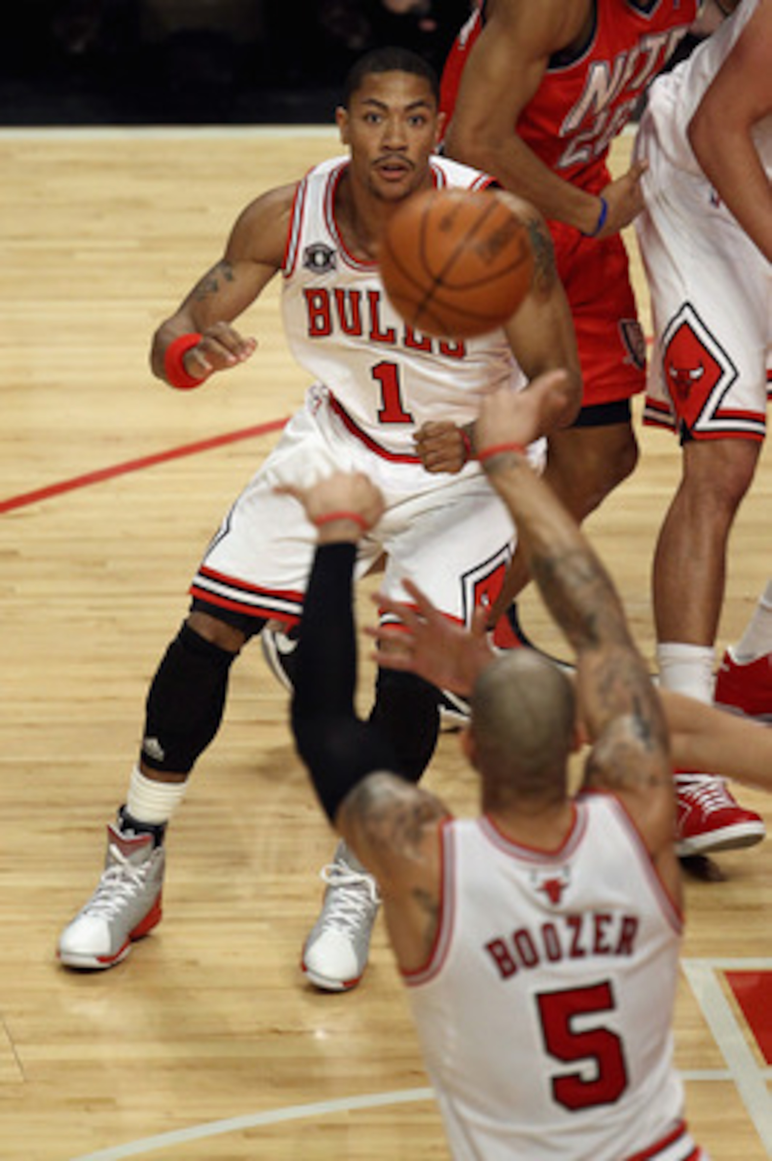 CHICAGO, IL - APRIL 13: Derrick Rose #1 of the Chicago Bulls moves to take a pass from teammate Carlos Boozer #5 against the New Jersey Nets at the United Center on April 13, 2011 in Chicago, Illinois. The Bulls defeated the Nets 97-92. NOTE TO USER: User