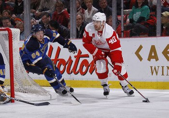 DETROIT, MI - MARCH 30:  Henrik Zetterberg #40 of the Detroit Red Wings skates with the puck along side Nikita Nikitin #64 of the St. Louis Blues at Joe Louis Arena on March 30, 2011 in Detroit, Michigan.  (Photo by Gregory Shamus/Getty Images)