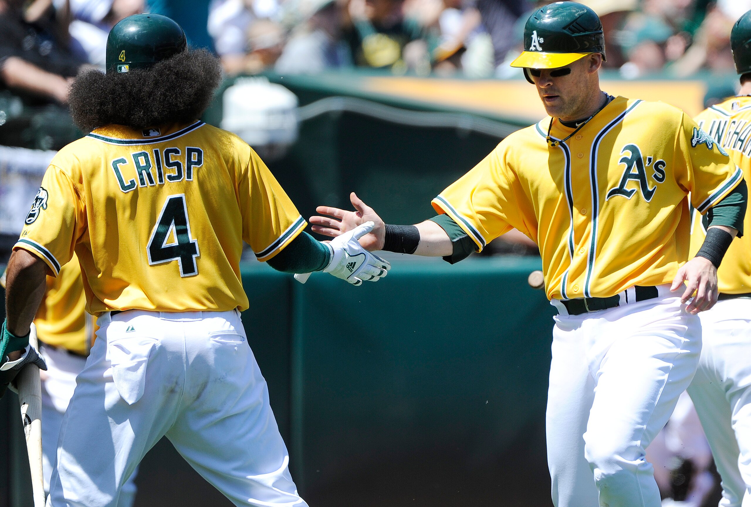 OAKLAND, CA - MAY 1:  Daric Barton  (R) slaps hand with teammate Coco Crisp #4 of the Oakland Athletics after they both scored on Conor Jackson's double in the bottom of the first inning against the Texas Rangers during a MLB baseball game at the Oakland-