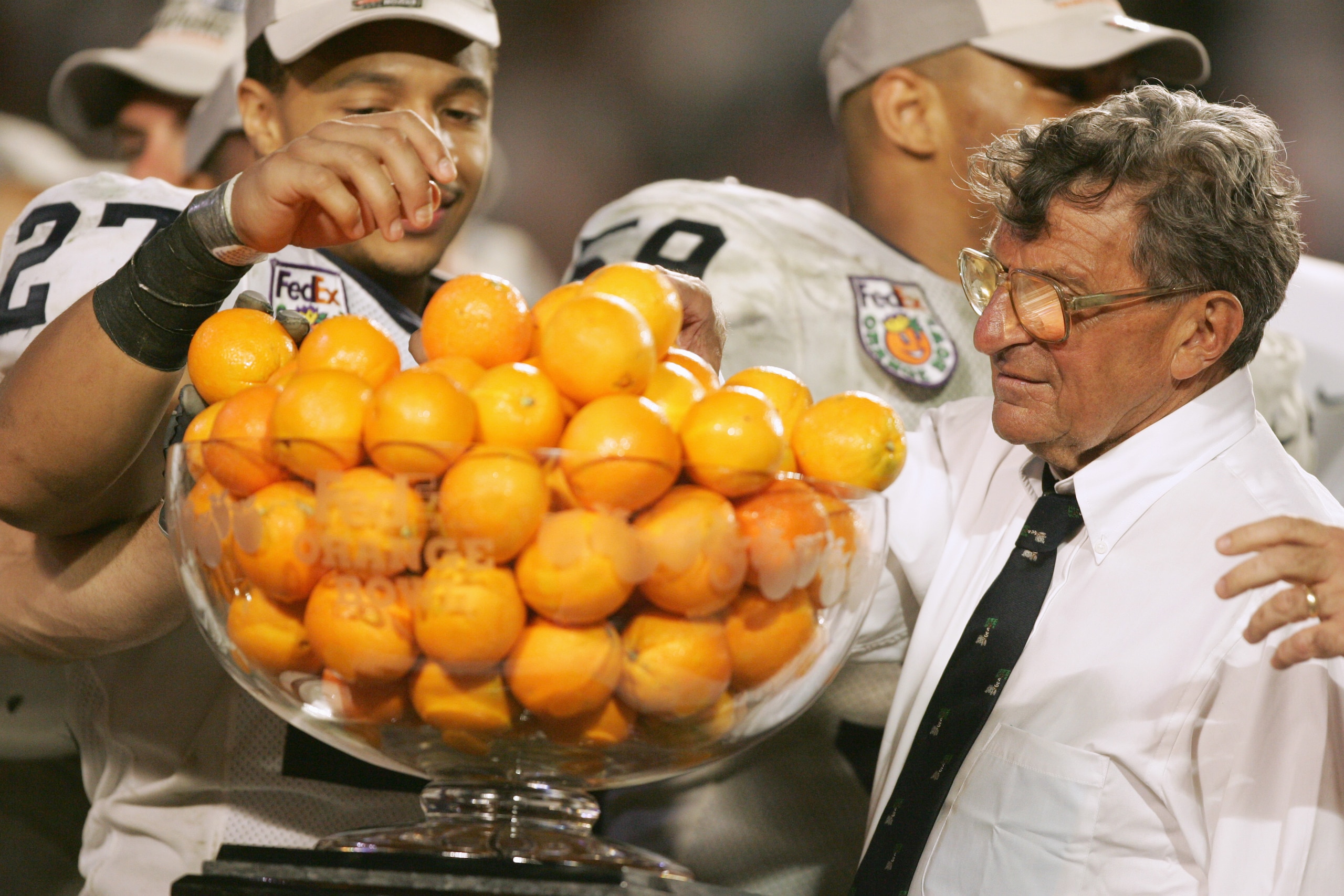 MIAMI GARDENS, FL - JANUARY 3:  Head coach Joe Paterno of the Penn State Nittany Lions takes an orange from the Championship Trophy after defeating Florida State Seminoles in the Fed Ex Orange Bowl at Dolphins Stadium on January 3, 2005 in Miami Gardens, 