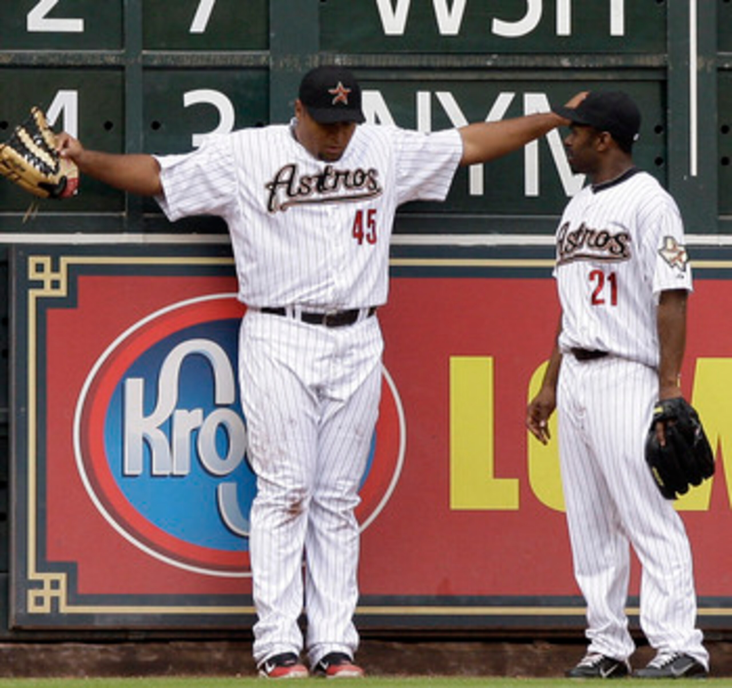 HOUSTON - APRIL 08:  Left fielder Carlos Lee #45 of the Houston Astros takes a moment to regain his composure after slamming into the wall to make a catch at Minute Maid Park on April 8, 2011 in Houston, Texas. Center fielder Michael Bourn checks with Lee