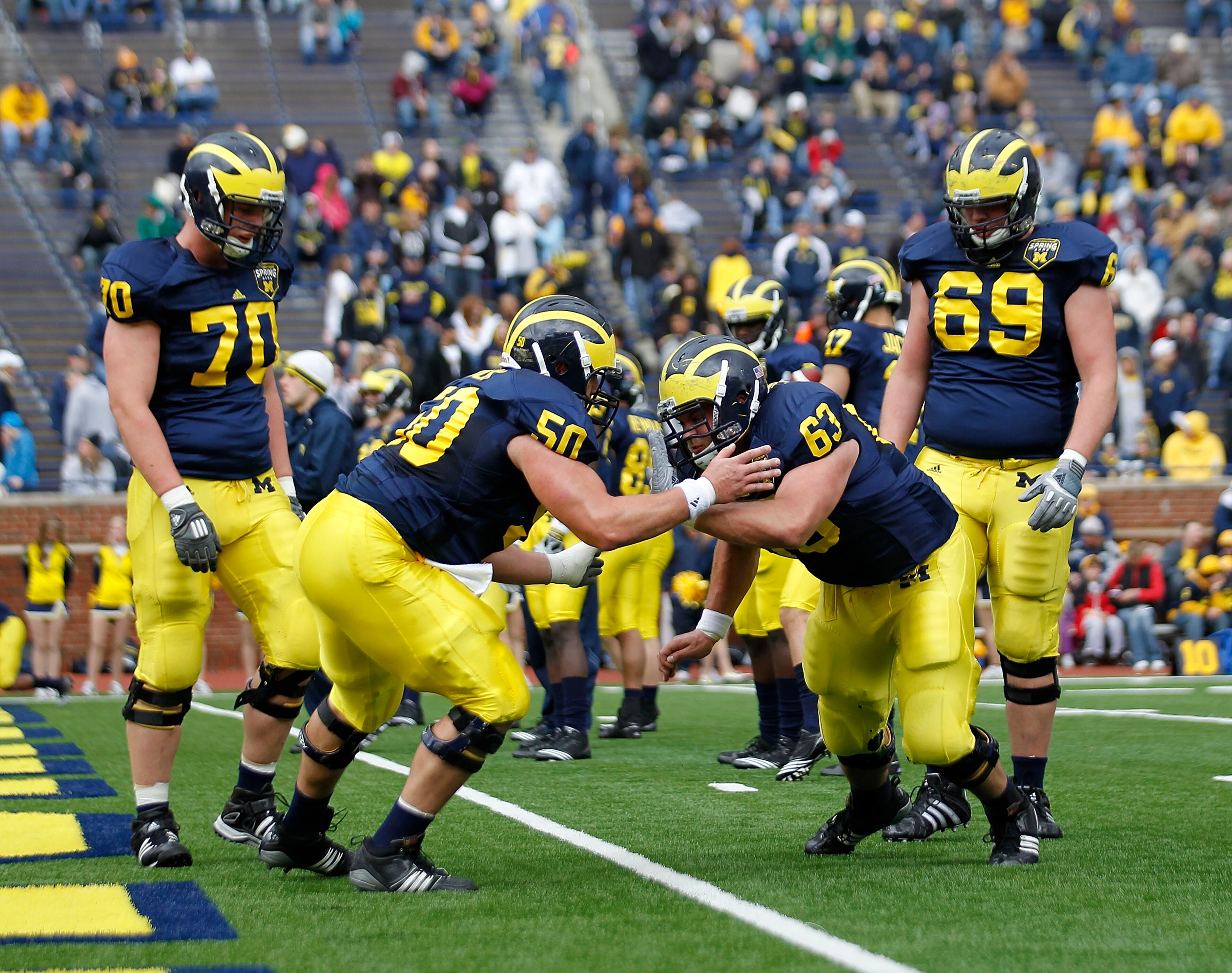 ANN ARBOR, MI - APRIL 16: David Molk #50 and Rocko Khoury #60 of the Michigan Wolverines run through the pre-game drills during the annual Spring Game at Michigan Stadium on April 16, 2011 in Ann Arbor, Michigan.  (Photo by Leon Halip/Getty Images)