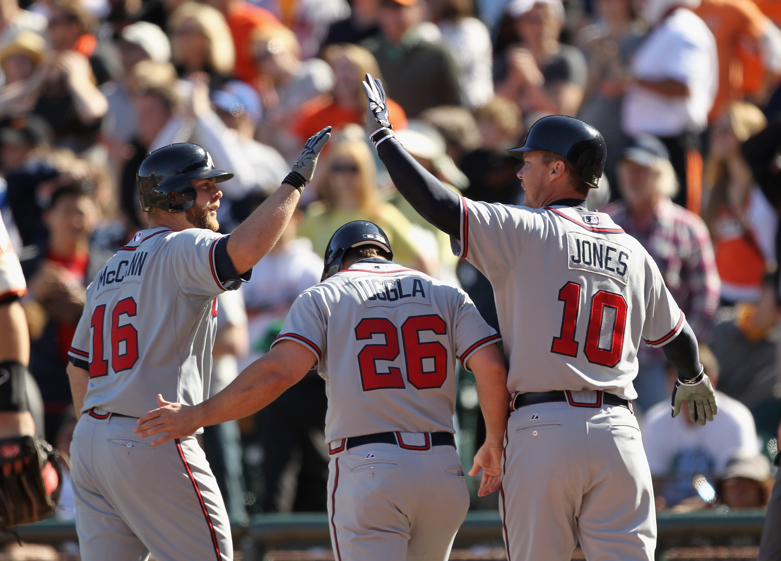 SAN FRANCISCO, CA - APRIL 24:  Brian McCann #16, Dan Uggla #26 and Chipper Jones #10 of the Atlanta Braves celebrate after Uggla and Jones scored in the 10th inning against the San Francisco Giants at AT&T Park on April 24, 2011 in San Francisco, Californ