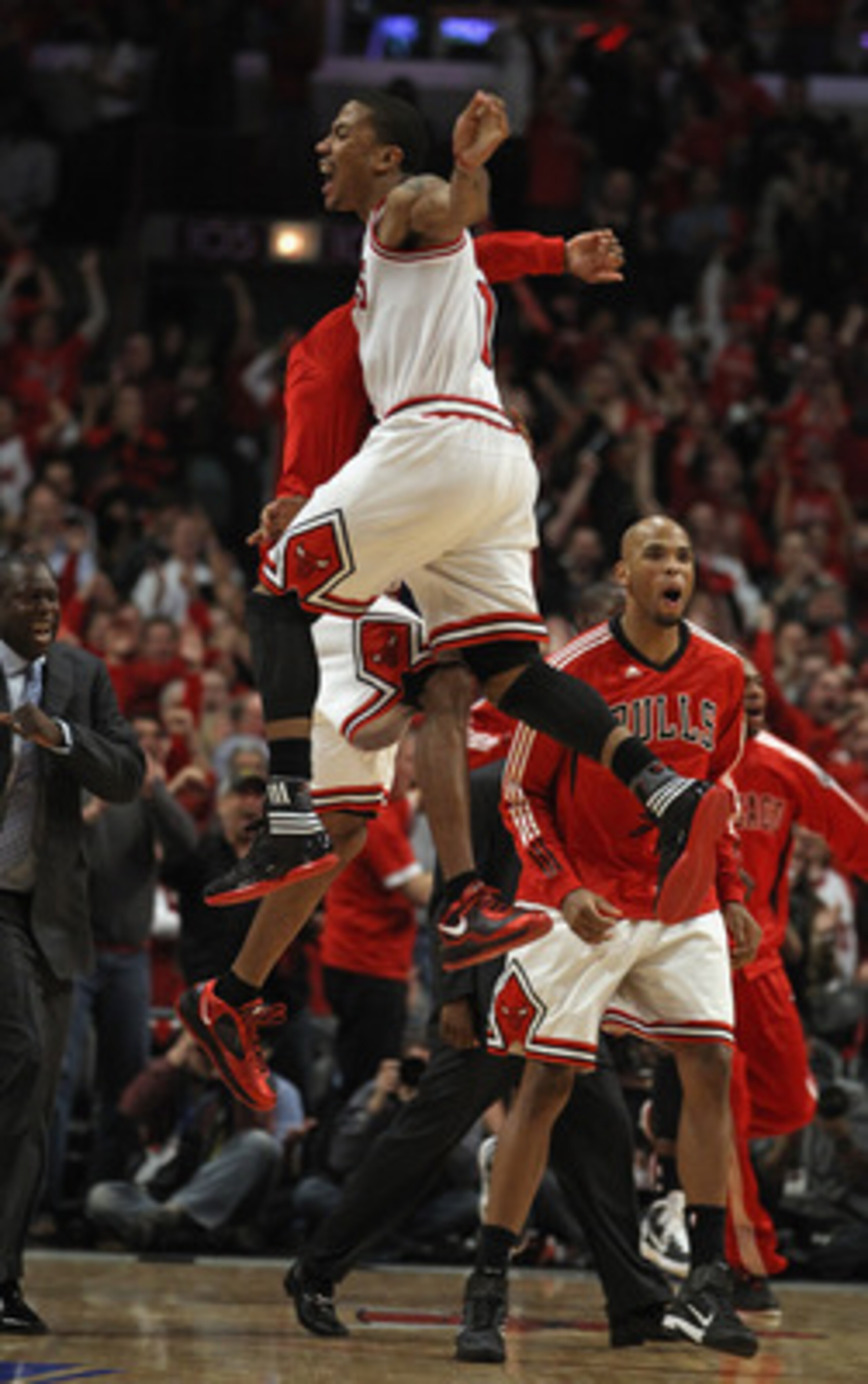 CHICAGO, IL - APRIL 16: Derrick Rose #1 of the Chicago Bulls jumps in the air with teammate C.J. Watson #32 as Taj Gibson #22 runs onto the court in celebratiuon of a win against the Indiana Pacers in Game One of the Eastern Conference Quarterfinals in th