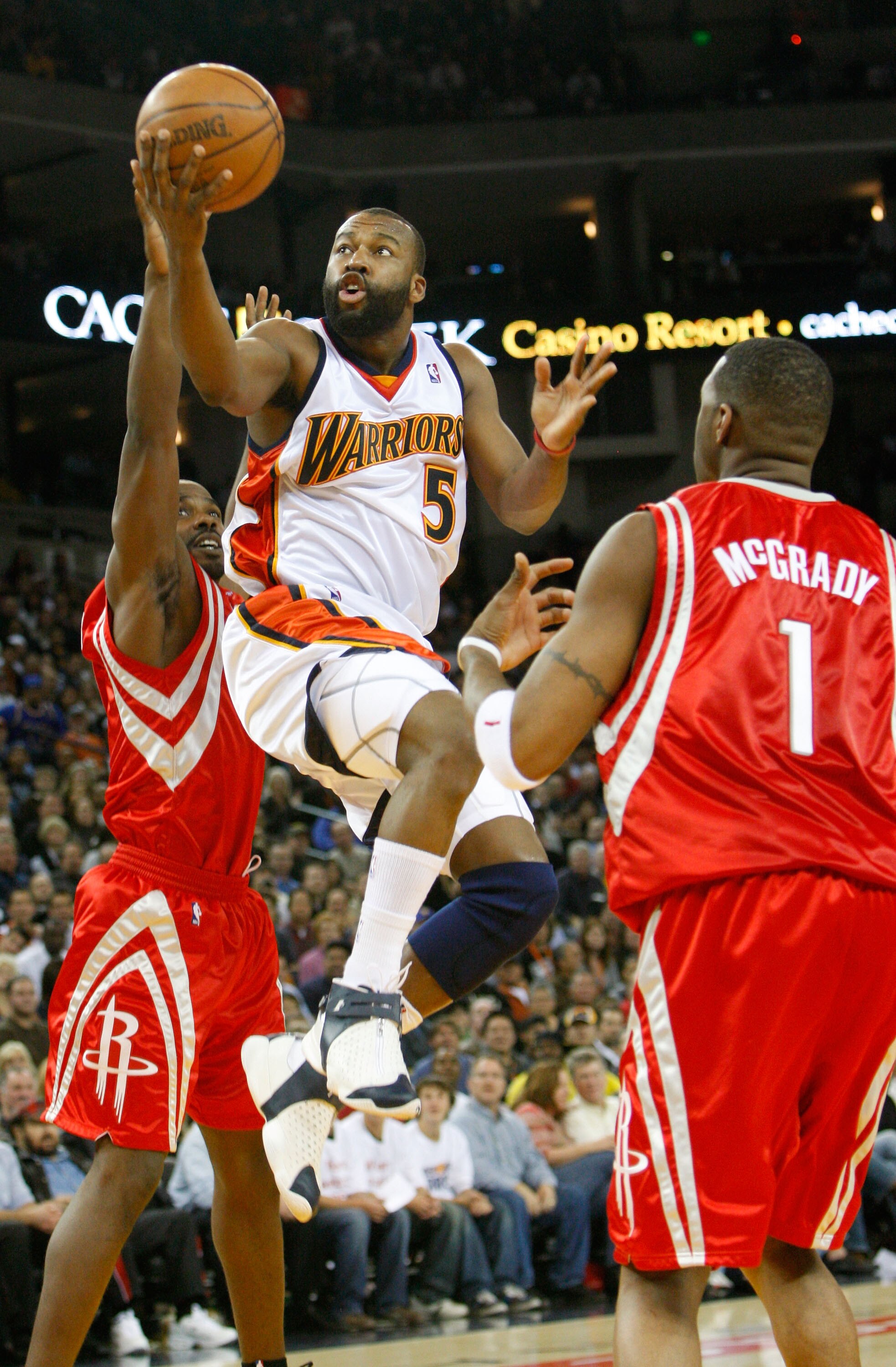 OAKLAND, CA - NOVEMBER 29:  Baron Davis #5 of the Golden State Warriors goes up for a shot as Tracy McGrady #1 of the Houston Rockets looks on during the second half November 29, 2007 at the Oracle Arena in Oakland, California. NOTE TO USER: User expressl