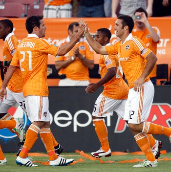 HOUSTON - APRIL 29:  Forward Will Bruin #12 of the Houston Dynamo is congratulated by Hunter Freeman #21after scoring in the first half against D.C. United at Robertson Stadium on April 29, 2011 in Houston, Texas.  (Photo by Bob Levey/Getty Images)