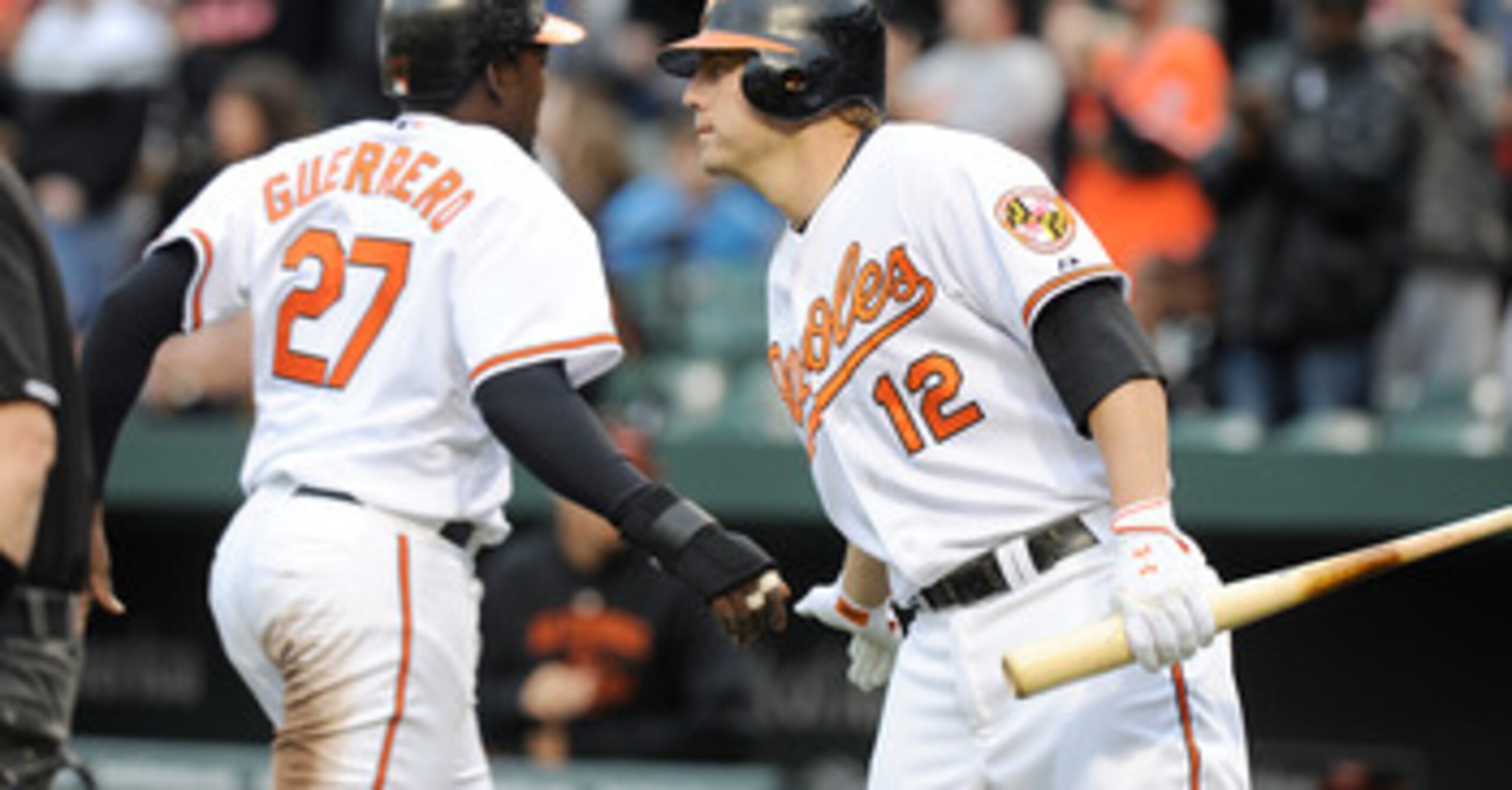 BALTIMORE, MD - APRIL 09:  Vladimir Guerrero #27 of the Baltimore Orioles is congratulated by Mark Reynolds #12 after scoring against the Texas Rangers at Oriole Park at Camden Yards on April 9, 2011 in Baltimore, Maryland.  (Photo by Greg Fiume/Getty Ima