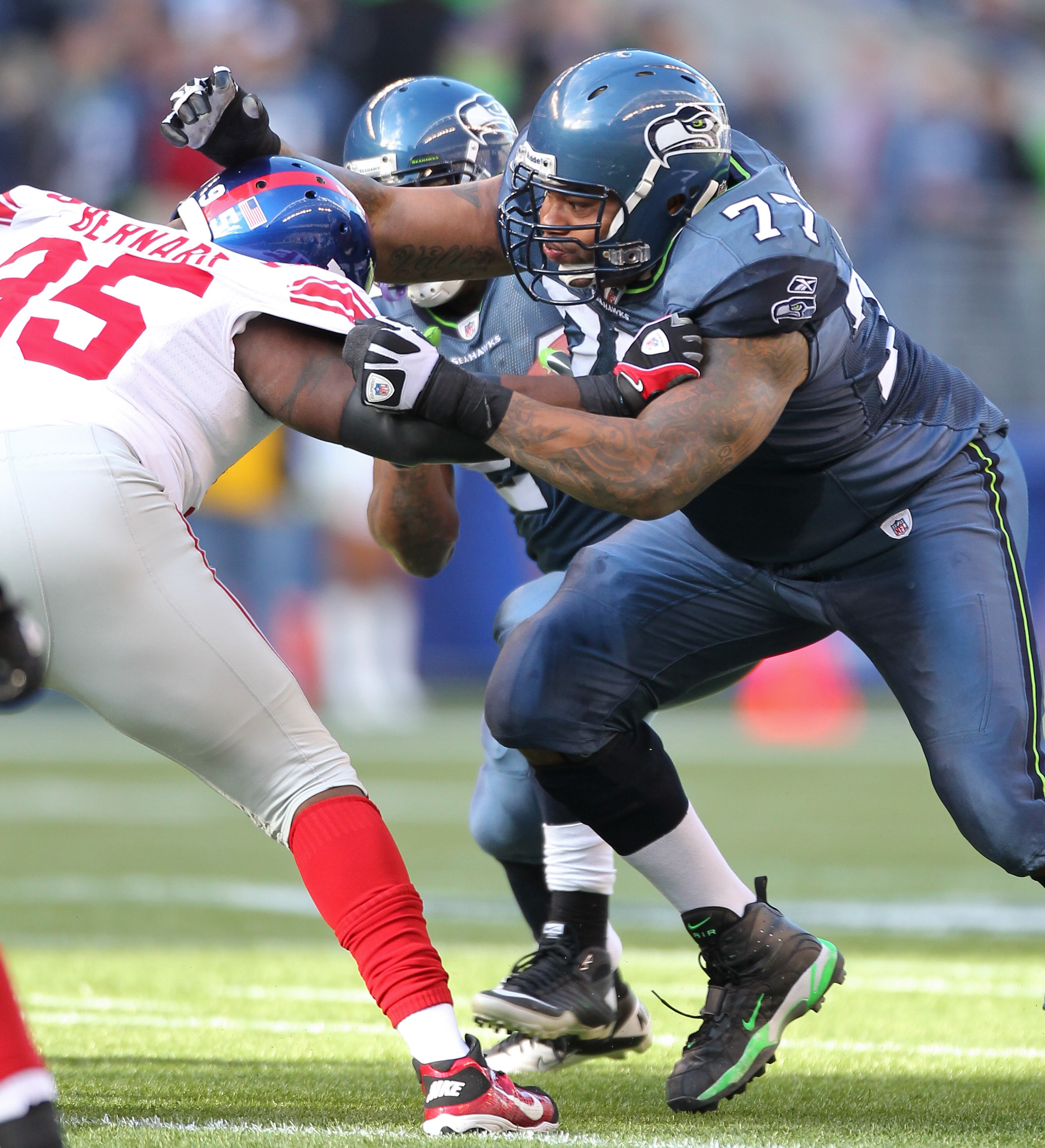 SEATTLE - NOVEMBER 07:  Right guard Stacy Andrews #77 of the Seattle Seahawks blocks Rocky Bernard #95 of the New York Giants at Qwest Field on November 7, 2010 in Seattle, Washington. The Giants defeated the Seahawks 41-7. (Photo by Otto Greule Jr/Getty