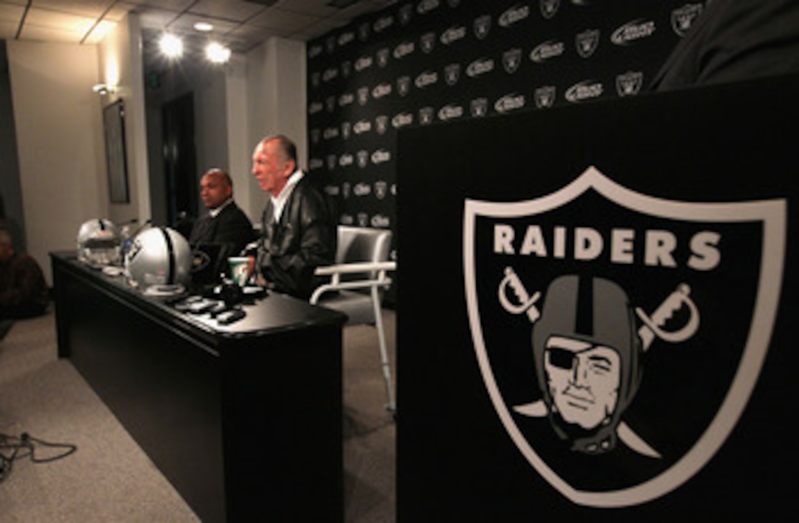 ALAMEDA, CA - JANUARY 18:  New Oakland Raiders coach Hue Jackson (L) looks on as Raiders owner Al Davis speaks during a press conference on January 18, 2011 in Alameda, California. Hue Jackson was introduced as the new coach of the Oakland Raiders, replac