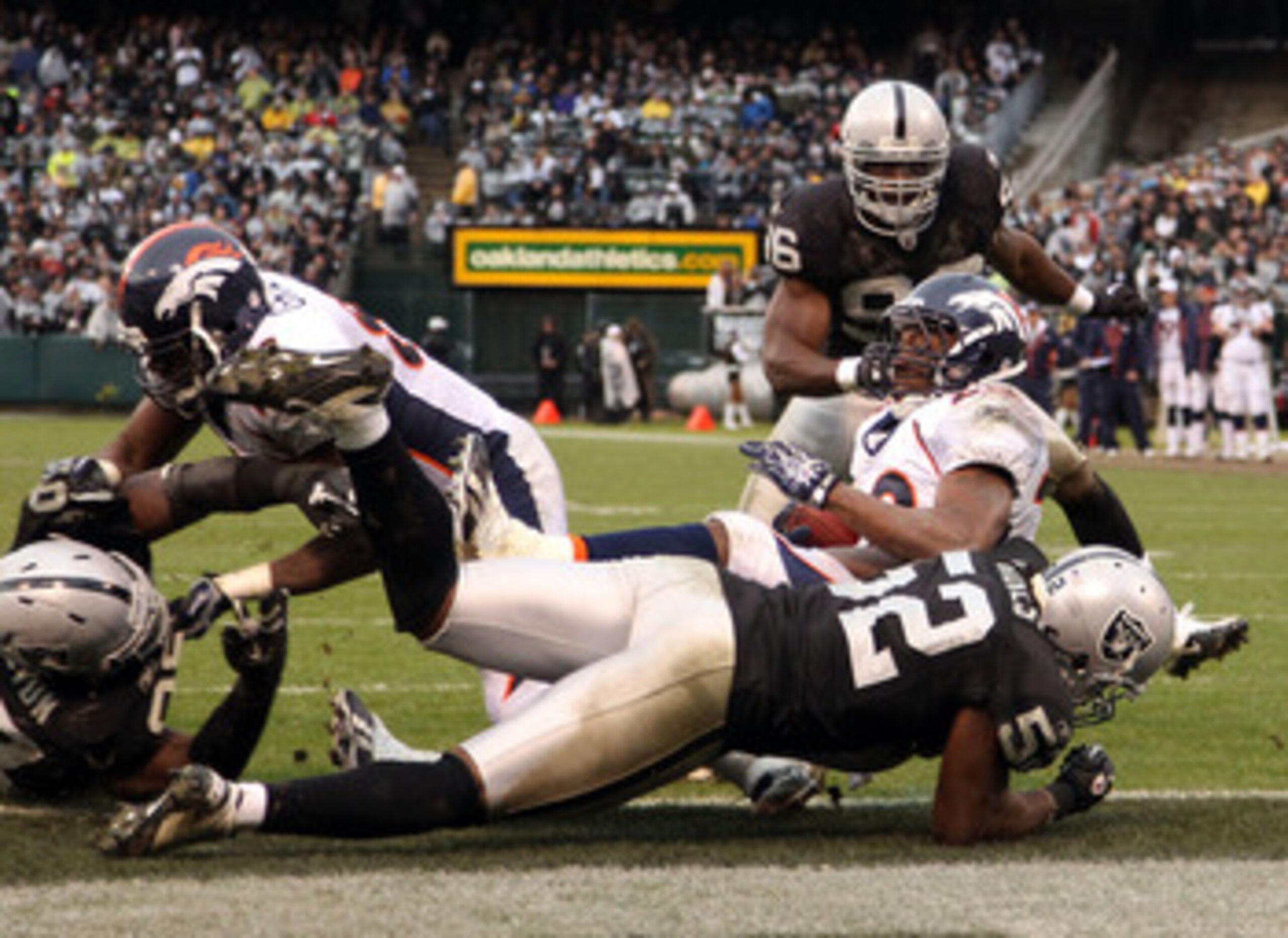 OAKLAND, CA - DECEMBER 19:  Quentin Groves #52 of the Oakland Raiders stops Correll Buckhalter #28 of the Denver Broncos for a safety at Oakland-Alameda County Coliseum on December 19, 2010 in Oakland, California.  (Photo by Ezra Shaw/Getty Images)