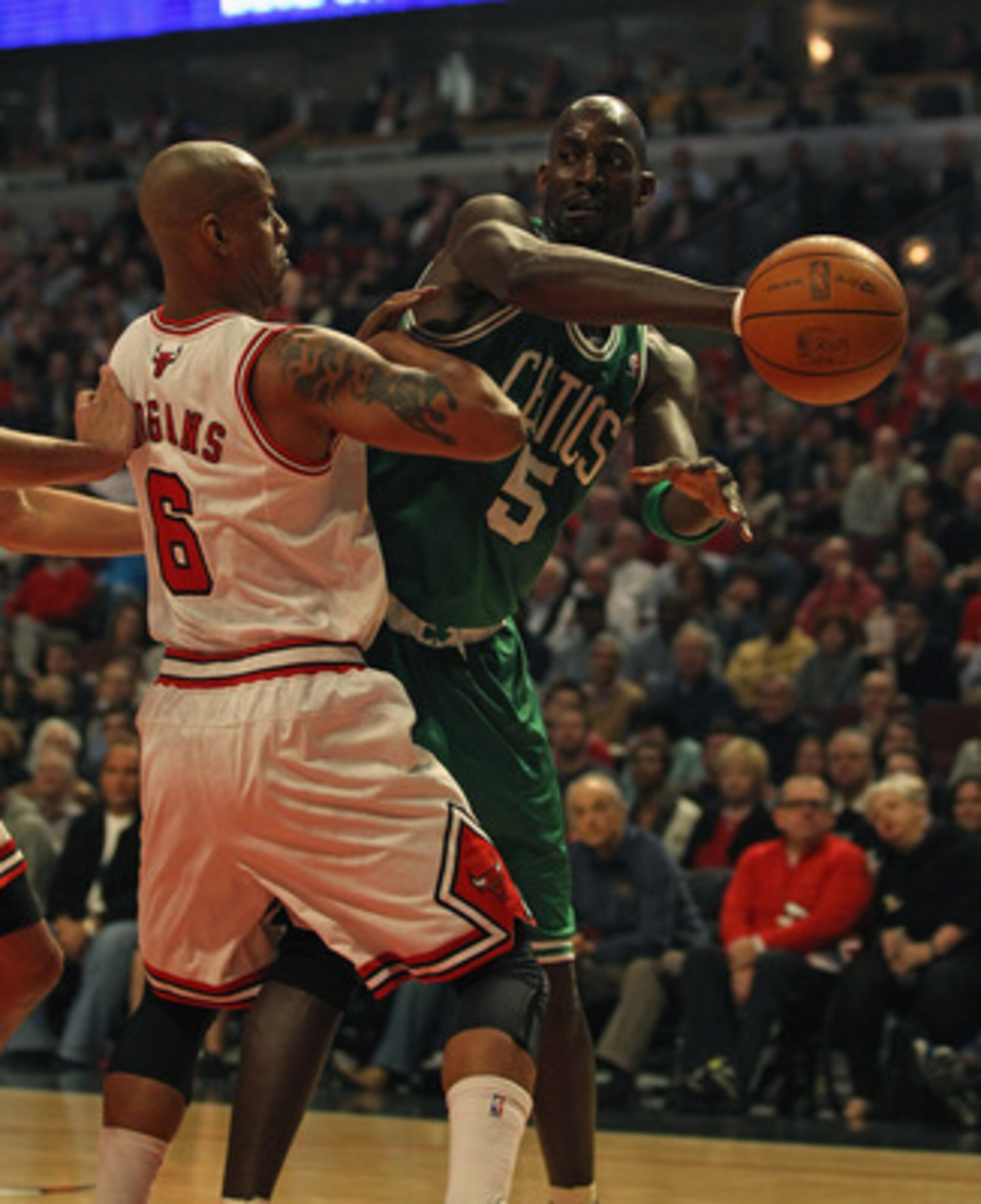 CHICAGO, IL - APRIL 07: Kevin Garnett #5 of the Boston Celtics passes the ball around Keith Bogans #6 of the Chicago Bulls at United Center on April 7, 2011 in Chicago, Illinois. NOTE TO USER: User expressly acknowledges and agrees that, by downloading an
