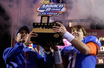 LAS VEGAS, NV - DECEMBER 22:  Head coach Chris Petersen (L) and quarterback Kellen Moore #11 of the Boise State Broncos hold up a trophy as they celebrate their 26-3 victory over the Utah Utes in the MAACO Bowl Las Vegas at Sam Boyd Stadium December 22, 2