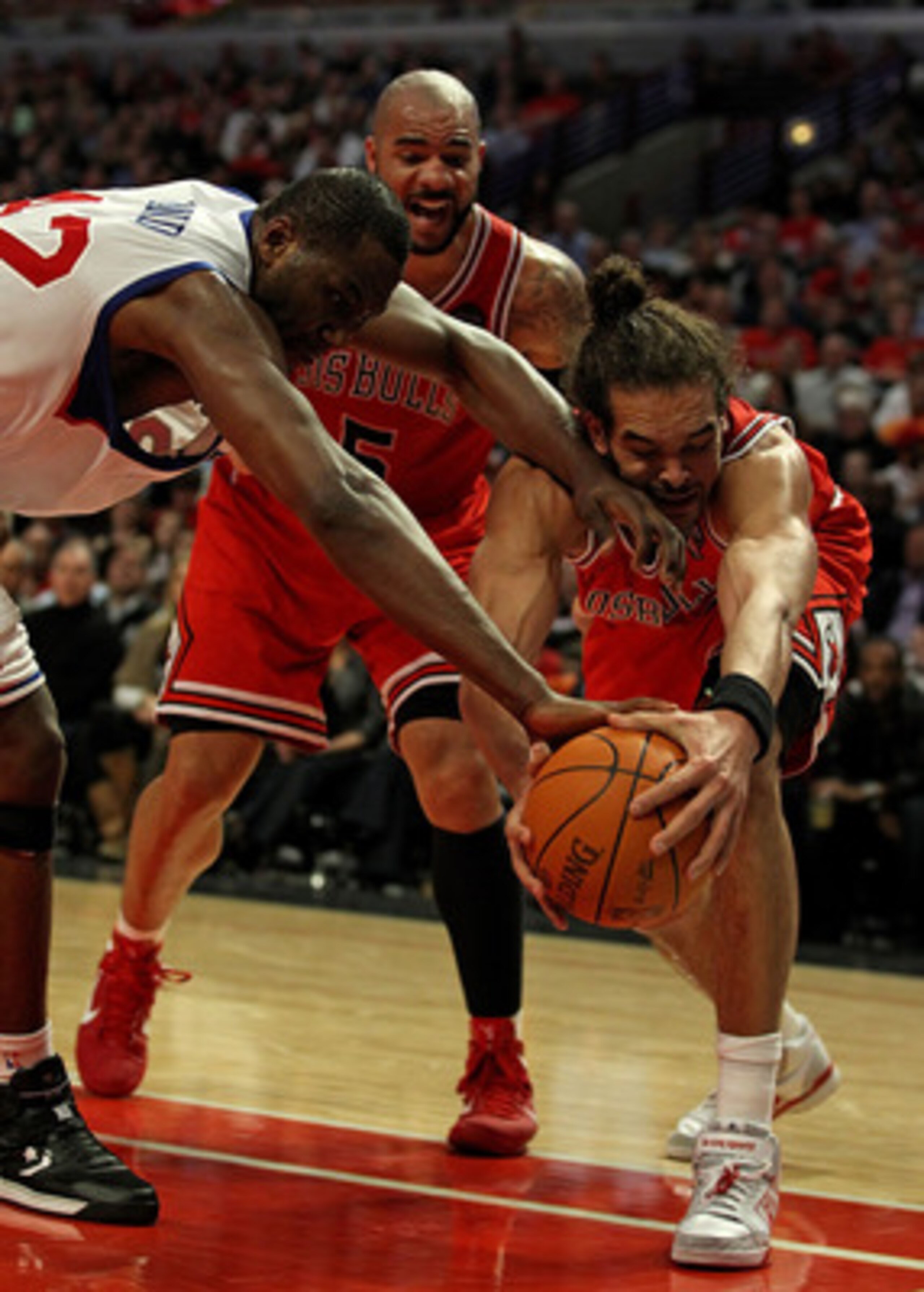 CHICAGO, IL - MARCH 28: Joakim Noah #13 of the Chicago Bulls battles for the ball with Elton Brand #42 of the Philadelphia 76ers in front of Carlos Boozer #5 at the United Center on March 28, 2011 in Chicago, Illinois. The 76ers defeated the Bulls 97-85. CHICAGO, IL - MARCH 28: Joakim Noah #13 of the Chicago Bulls battles for the ball with Elton Brand #42 of the Philadelphia 76ers in front of Carlos Boozer #5 at the United Center on March 28, 2011 in Chicago, Illinois. The 76ers defeated the Bulls 97-85.