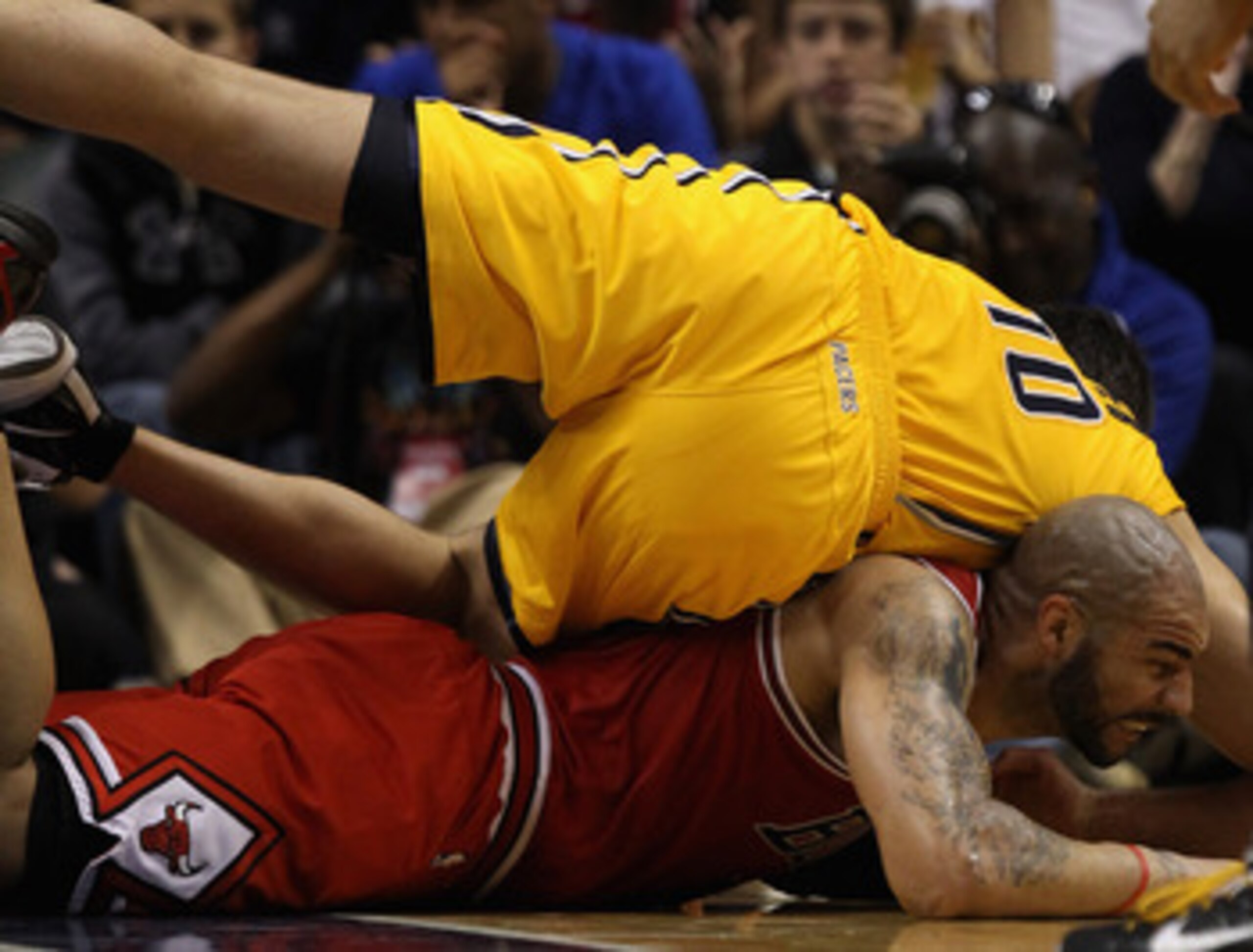 INDIANAPOLIS, IN - APRIL 23: Jeff Foster #10 of the Indiana Pacers lands on top of Carlos Boozer #5 of the Chicago Bulls during a scramble for a loose ball in Game Four of the Eastern Conference Quarterfinals in the 2011 NBA Playoffs at Conseco Fieldhouse INDIANAPOLIS, IN - APRIL 23: Jeff Foster #10 of the Indiana Pacers lands on top of Carlos Boozer #5 of the Chicago Bulls during a scramble for a loose ball in Game Four of the Eastern Conference Quarterfinals in the 2011 NBA Playoffs at Conseco Fieldhouse