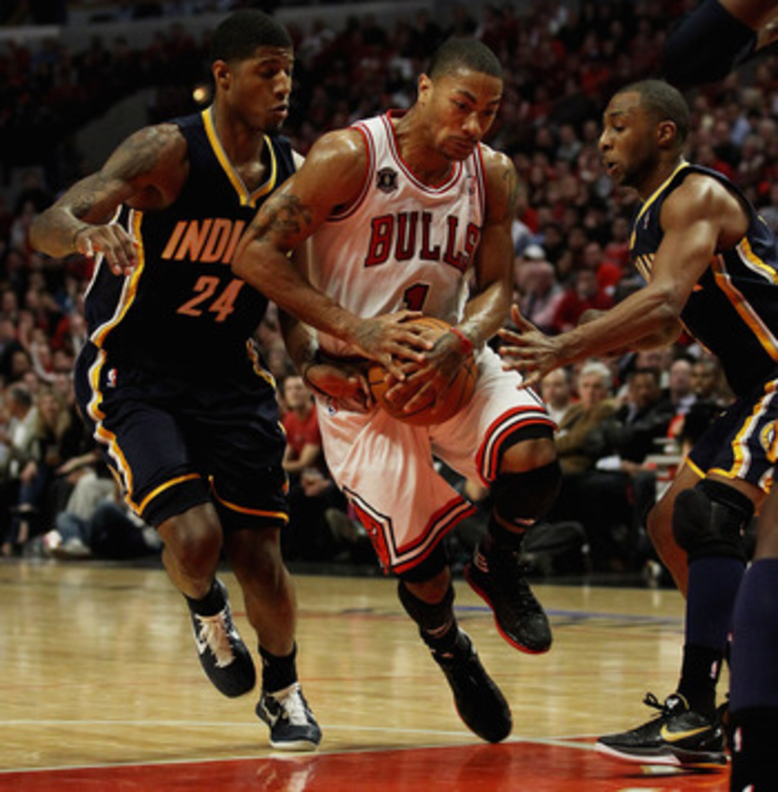 CHICAGO, IL - APRIL 18: Derrick Rose #1 of the Chicago Bulls drives between Paul George #24 and A.J. Price #12 of the Indiana Pacers in Game Two of the Eastern Conference Quarterfinals in the 2011 NBA Playoffs at the United Center on April 18, 2011 in Chi CHICAGO, IL - APRIL 18: Derrick Rose #1 of the Chicago Bulls drives between Paul George #24 and A.J. Price #12 of the Indiana Pacers in Game Two of the Eastern Conference Quarterfinals in the 2011 NBA Playoffs at the United Center on April 18, 2011 in Chi