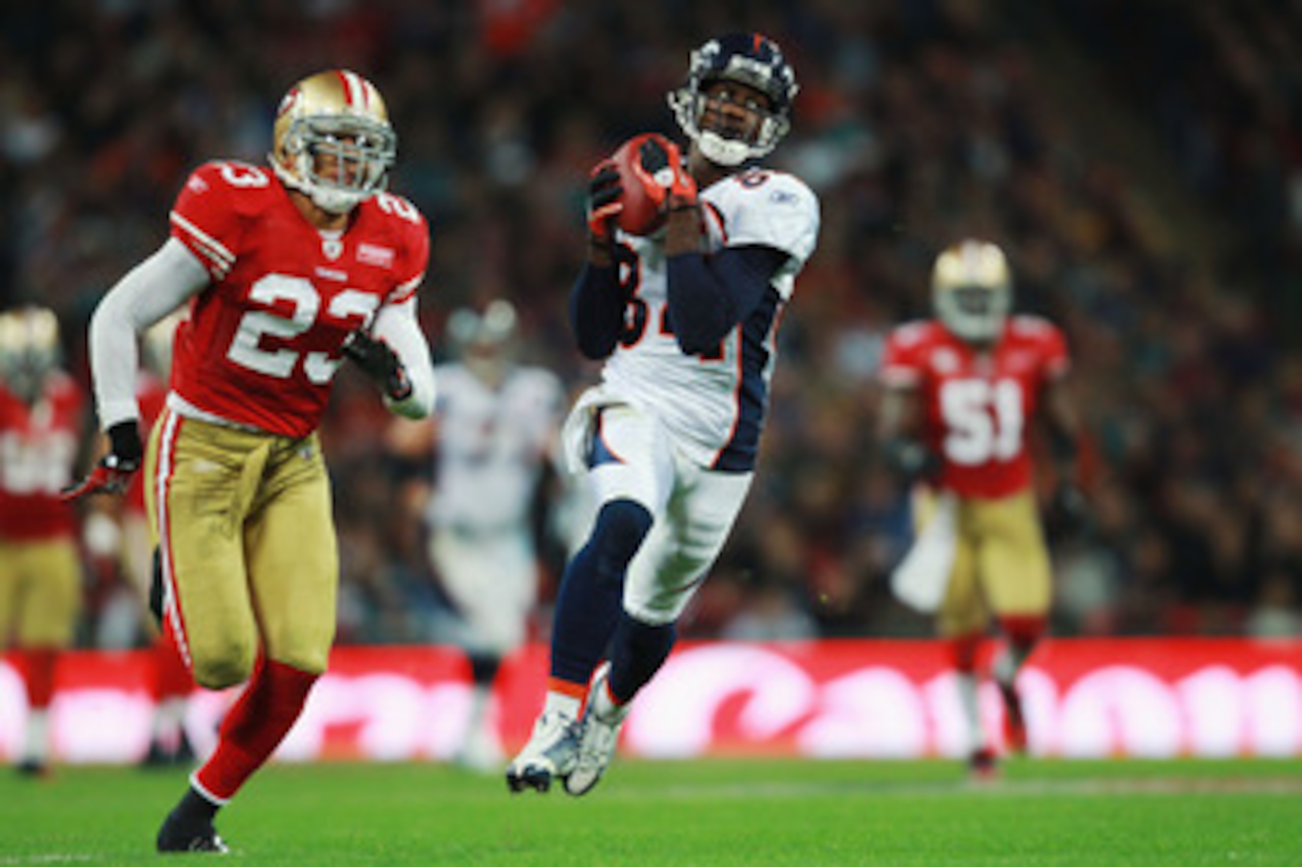 LONDON, ENGLAND - OCTOBER 31:  Brandon Lloyd #84 of Denver Broncos catches the ball ahead of Taylor Mays #23 of San Francisco 49ers during the NFL International Series match between Denver Broncos and San Francisco 49ers at Wembley Stadium on October 31, 