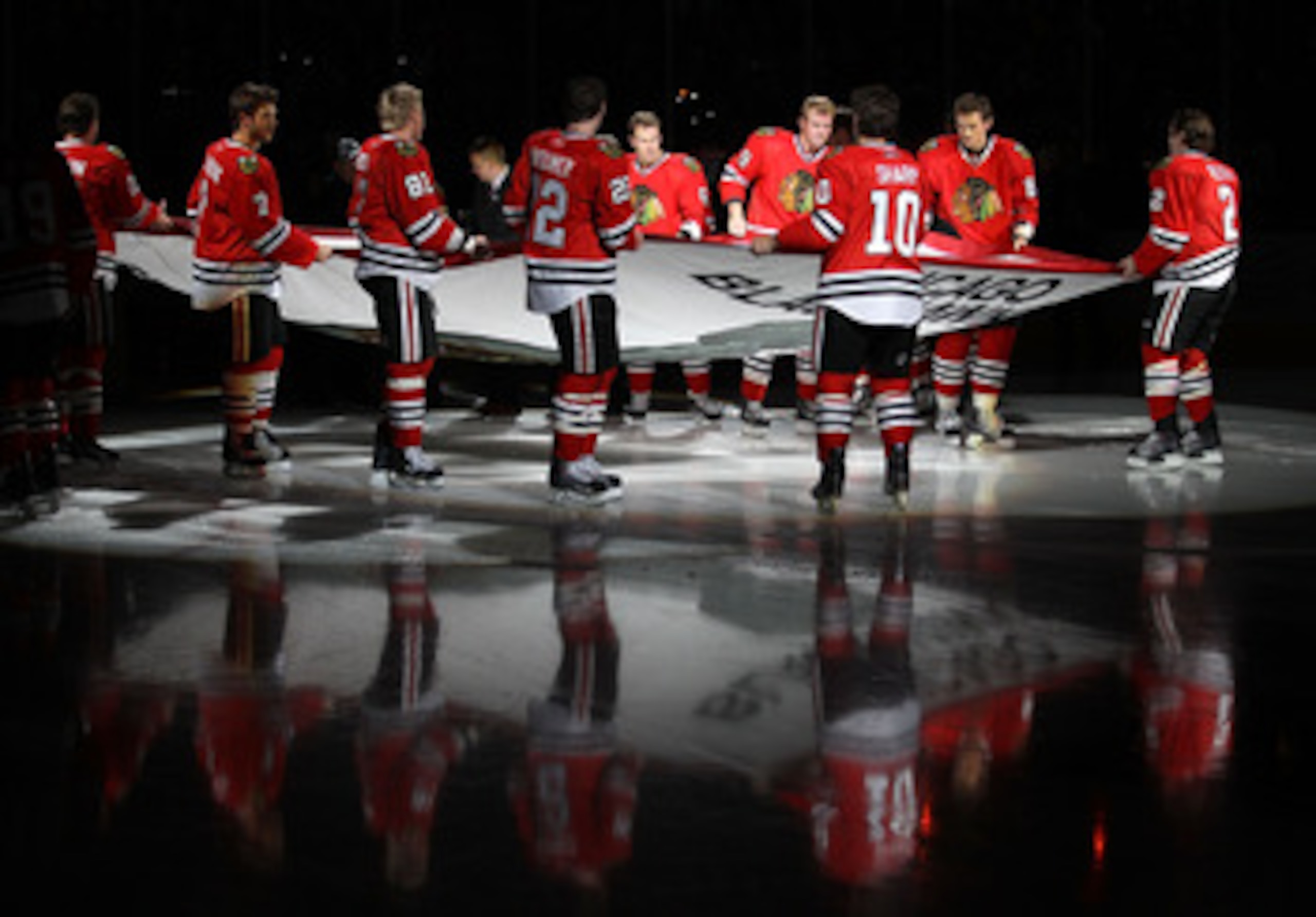 CHICAGO - OCTOBER 09: Members of the Chicago Blackhawks carry the Stanley Cup Championship banner across the ice in a ceremony before the Blackhawks season home opening game against the Detroit Red Wings at the United Center on October 9, 2010 in Chicago,