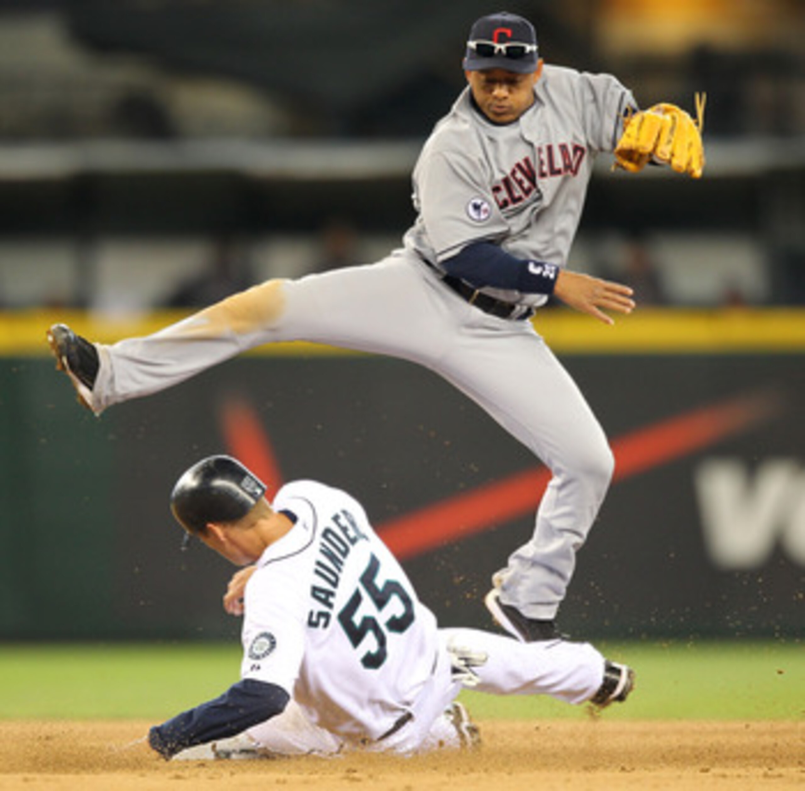 SEATTLE - APRIL 10: Second baseman Orlando Cabrera #20 of the Cleveland Indians hops over Michael Saunders #55 of the Seattle Mariners on a double play in the fifth inning at Safeco Field on April 10, 2011 in Seattle, Washington. (Photo by Otto Greule Jr SEATTLE - APRIL 10: Second baseman Orlando Cabrera #20 of the Cleveland Indians hops over Michael Saunders #55 of the Seattle Mariners on a double play in the fifth inning at Safeco Field on April 10, 2011 in Seattle, Washington. (Photo by Otto Greule Jr