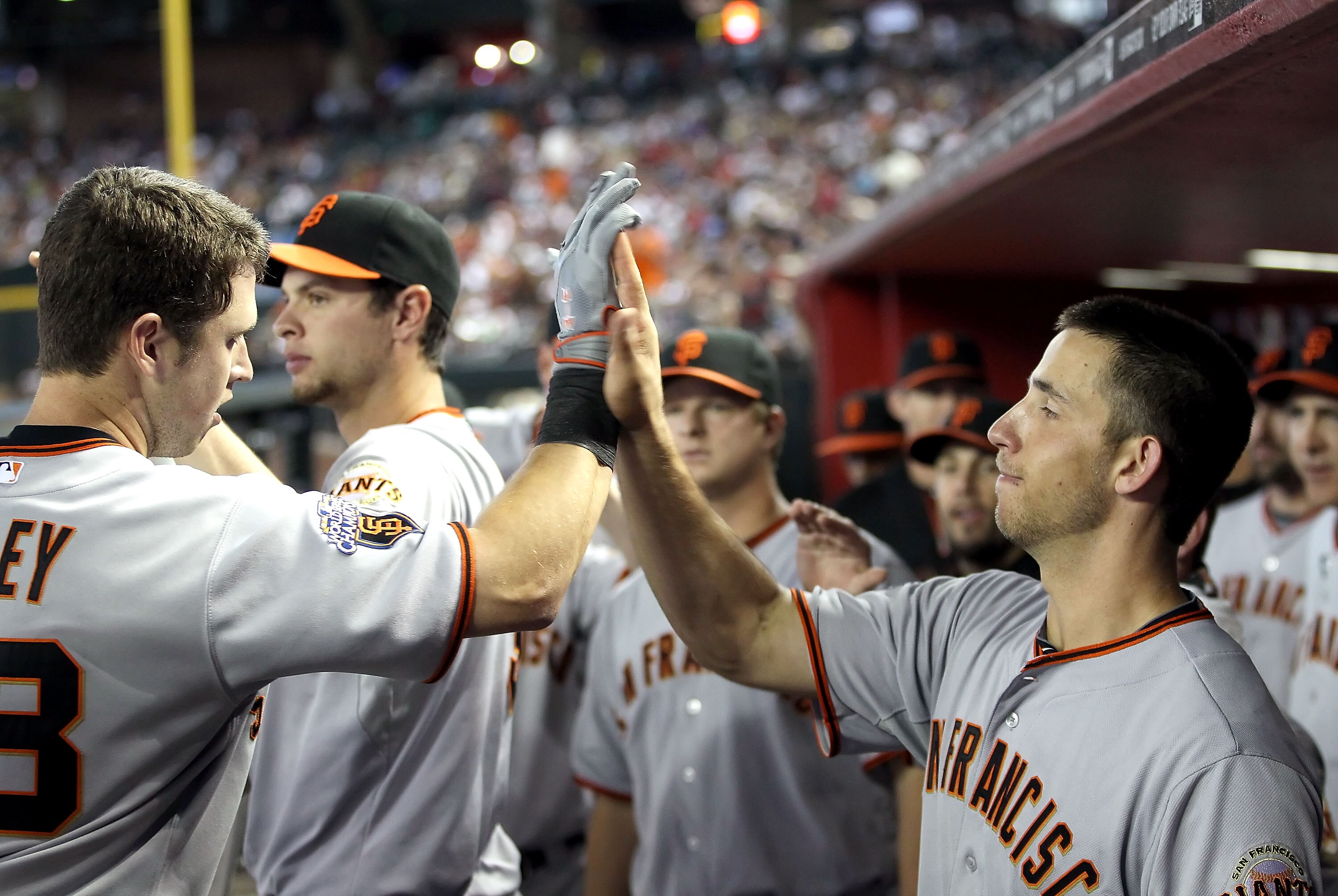 PHOENIX, AZ - APRIL 17:  Buster Posey #28 of the San Francisco Giants high fives teammate Madison Bumgarner #40 after Posey hit a two run home run against the Arizona Diamondbacks during the sixth inning of the Major League Baseball game at Chase Field on
