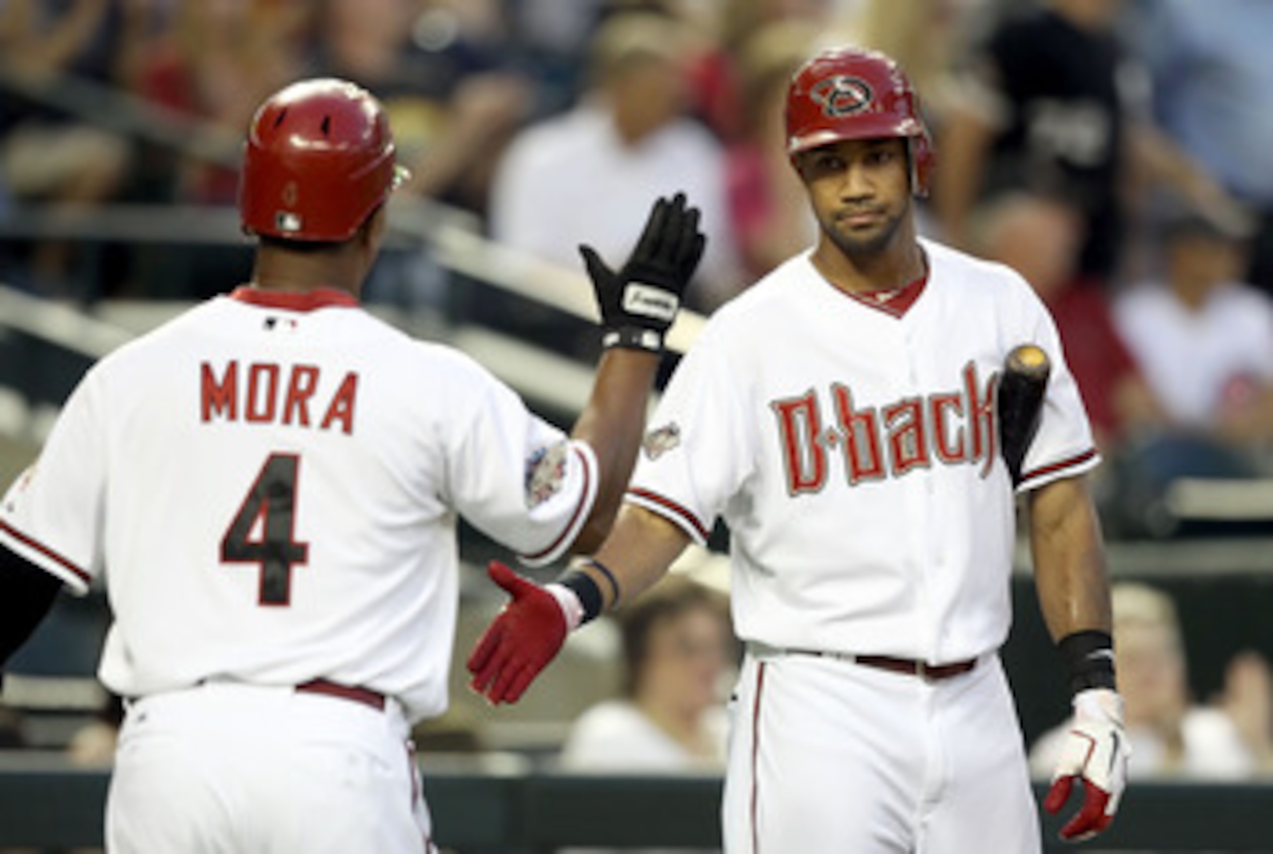 PHOENIX, AZ - APRIL 28:  Chris Young #24 of the Arizona Diamondbacks high fives teammate Melvin Mora #4 after scoring against the Chicago Cubs during the first inning of the Major League Baseball game at Chase Field on April 28, 2011 in Phoenix, Arizona.