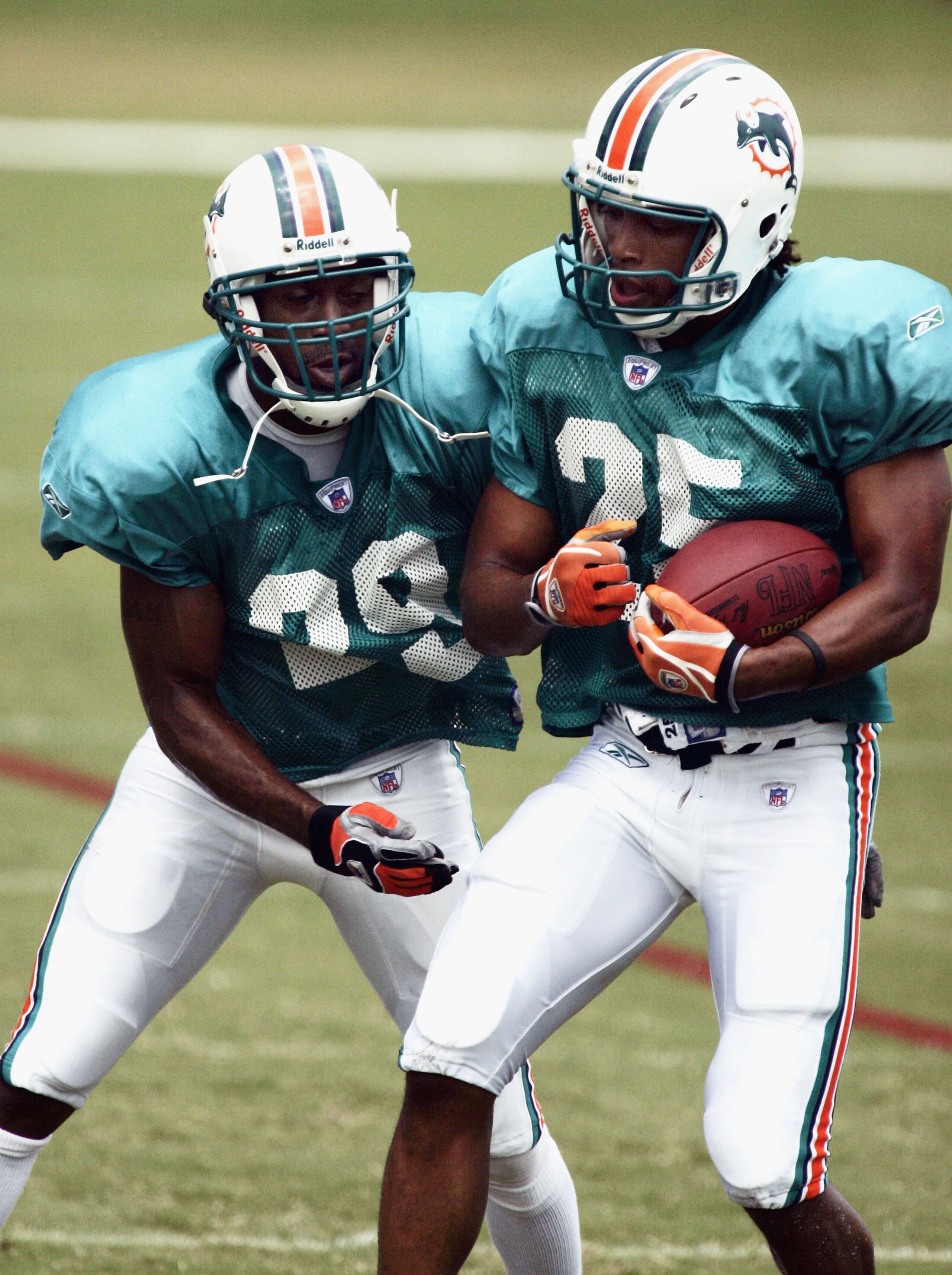 MIAMI - JULY 28: Corner back Reggie Howard #25 of the Miami Dolphins runs with the ball while teammate, corner back Sam Madison, makes contact during the Miami Dolphins training session at their training camp on July 28, 2005 in Davie, Florida. (Photo by 