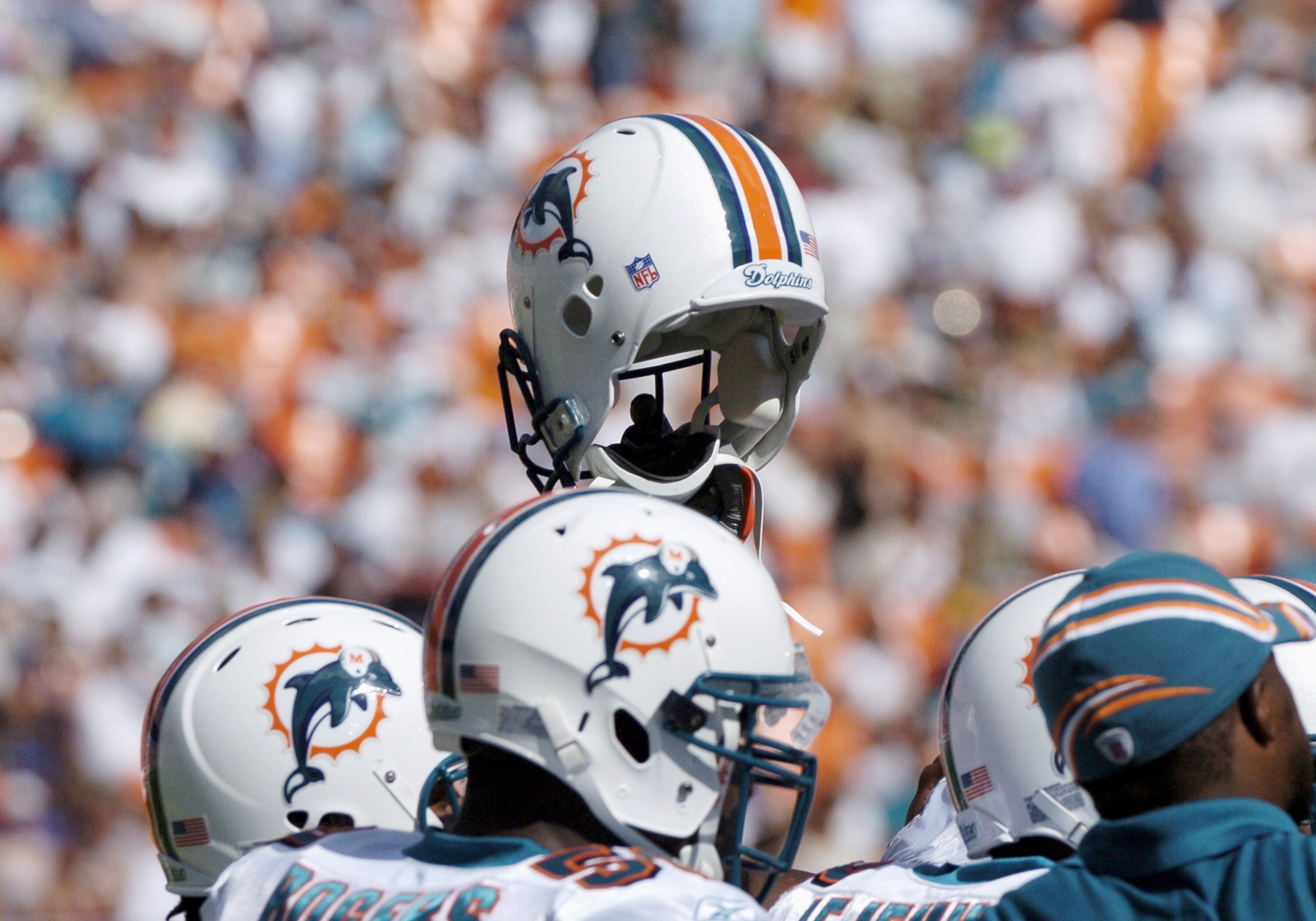 Miami Dolphins display unity by holding a helmet aloft before play against the Buffalo Bills December 4, 2005. The Dolphins defeated the Bills 24-23 on a touchdown with six seconds left in the  game.  (Photo by Al Messerschmidt/Getty Images)