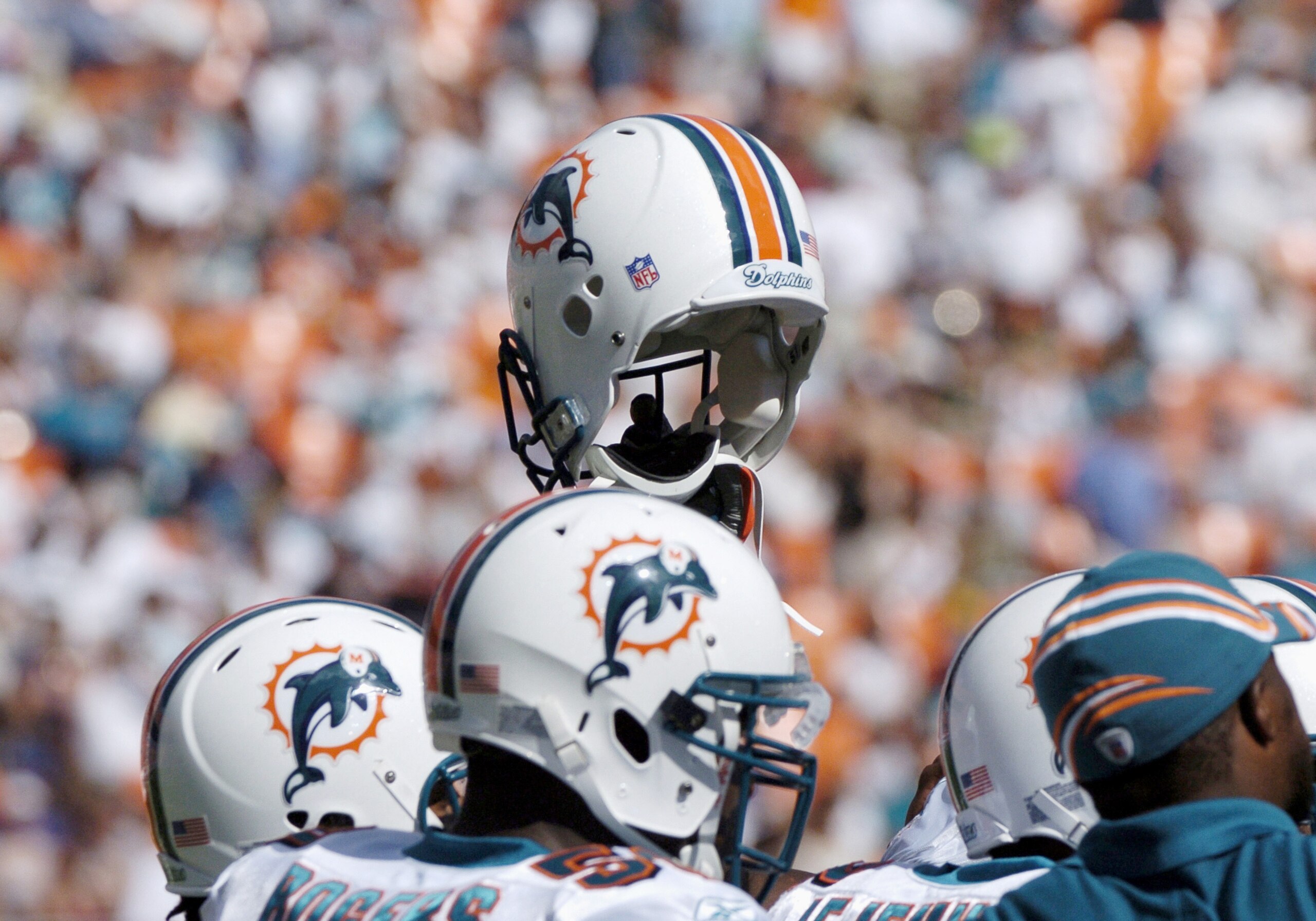 Miami Dolphins display unity by holding a helmet aloft before play against the Buffalo Bills December 4, 2005. The Dolphins defeated the Bills 24-23 on a touchdown with six seconds left in the  game.  (Photo by Al Messerschmidt/Getty Images)