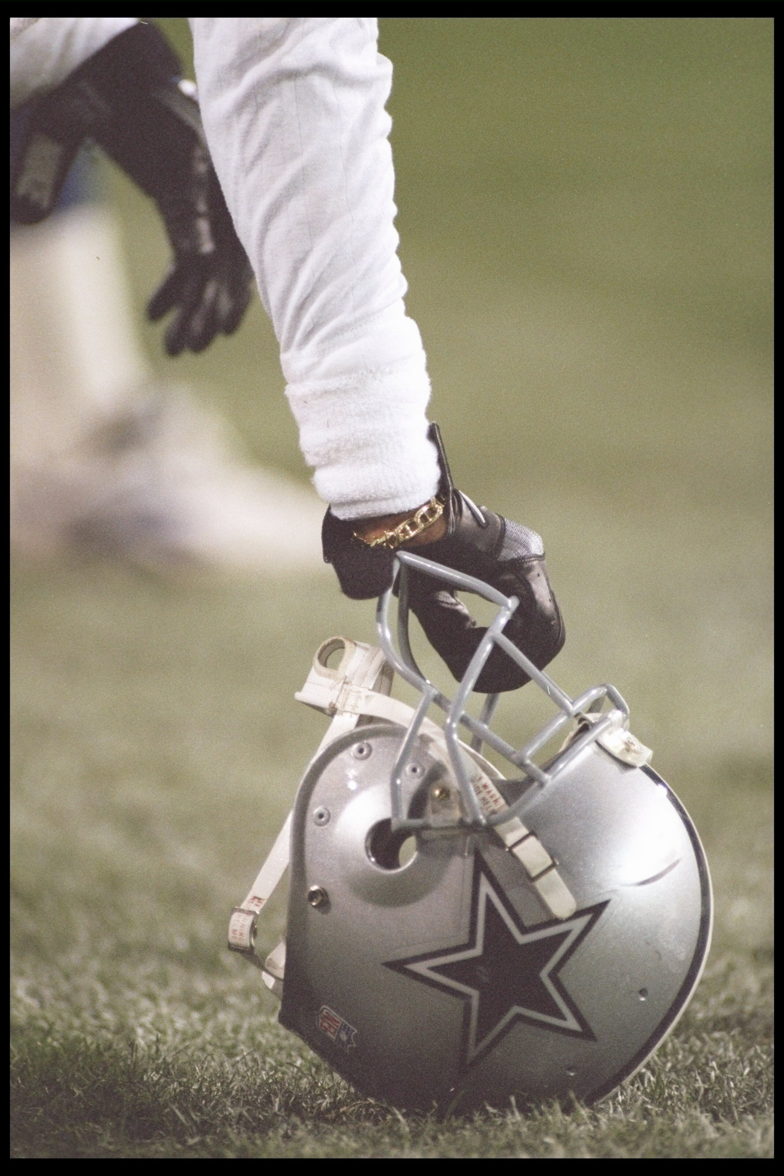 25 Dec 1995: A Dallas Cowboys player leans on his helmet during a game against the Arizona Cardinals at Sun Devil Stadium in Tempe, Arizona. The Cowboys won the game, 37-13.