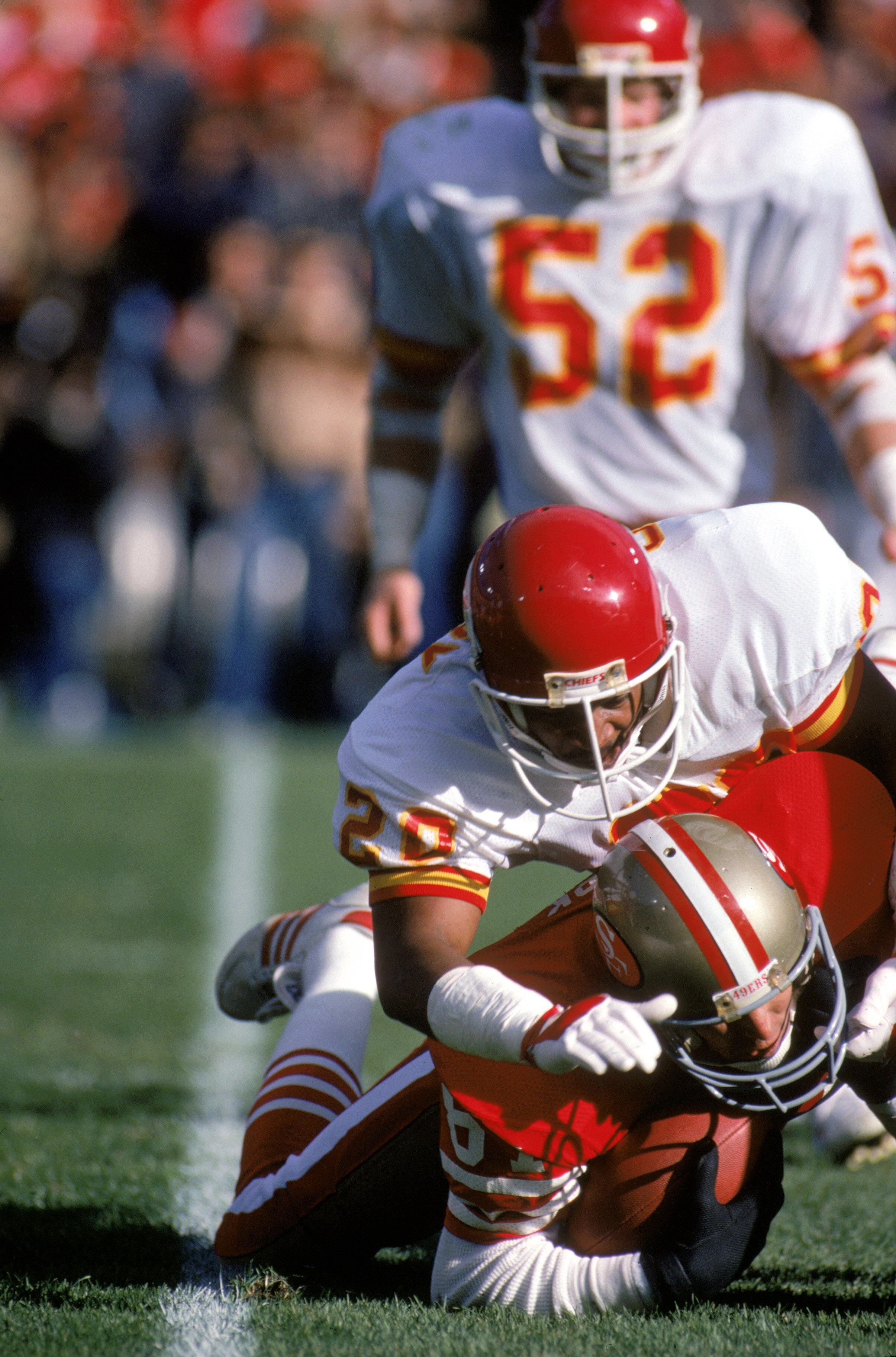 SAN FRANCISCO - NOVEMBER 17:  Defensive back Deron Cherry #20 of the Kansas City Chiefs takes down San Francisco 49ers wide receiver Dwight Clark #87 during a game at Candlestick Park on November 17, 1985 in San Francisco, California.  The 49ers won 31-3.