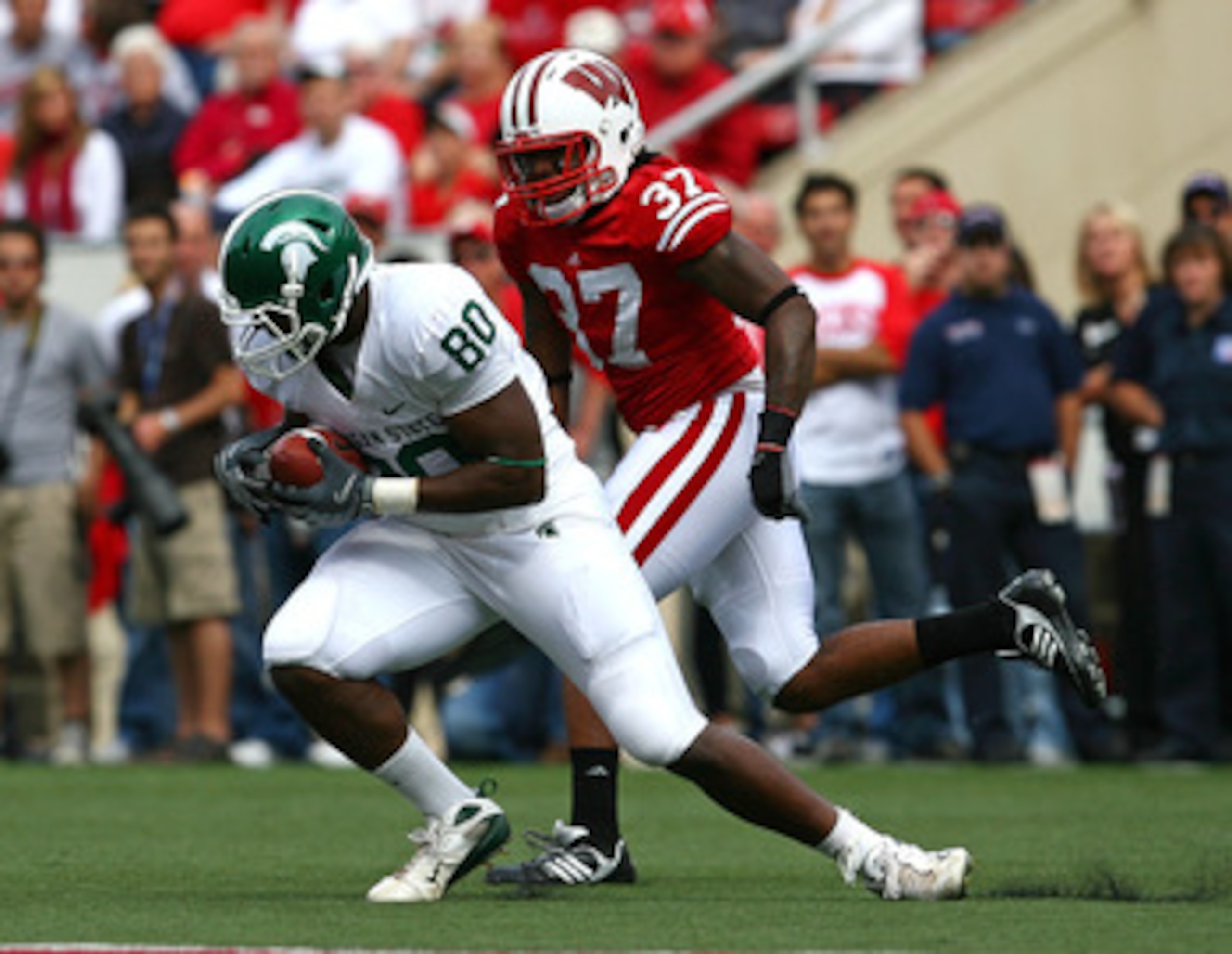 MADISON, WI - SEPTEMBER 26:  Dion Sims #80 of the Michigan State Spartans makes a catch in front of Kevin Claxton #37 of the Wisconsin Badgers on September 26, 2009 at Camp Randall Stadium in Madison, Wisconsin. Wisconsin defeated Michigan State 38-30. (P