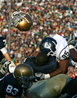 SOUTH BEND, IN - NOVEMBER 21: Armando Allen #5 of the Notre Dame Fighting Irish looses his helmut as he is hit at the goalline by Greg Lloyd #95 of the Univeristy of Connecticut Huskies at Notre Dame Stadium on November 21, 2009 in South Bend, Indiana. (P