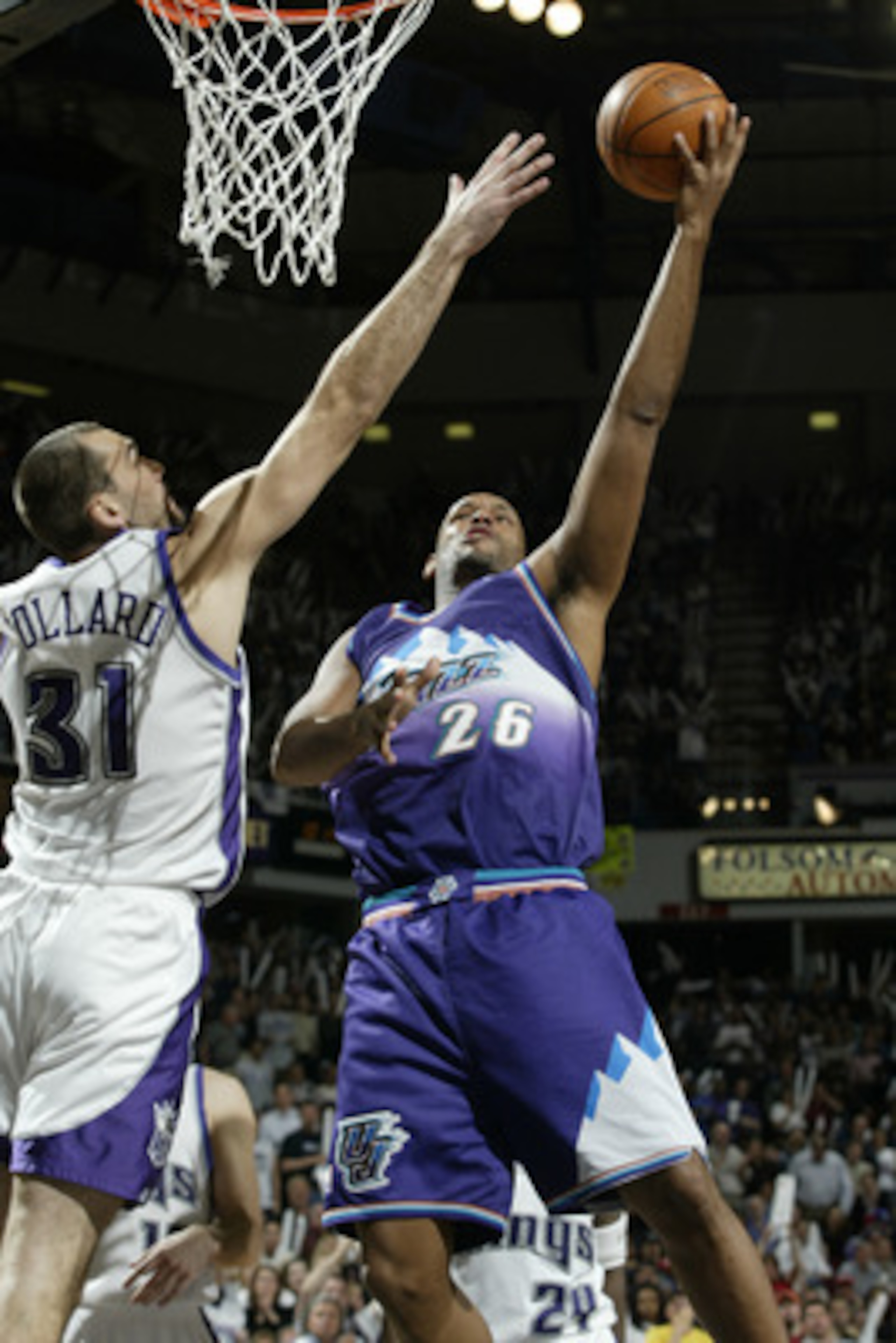 SACRAMENTO, CA - APRIL 30: John Amaechi #26 of the Utah Jazz shoots past Scot Pollard #31 of the Sacramento Kings in Game five of the Western Conference Quarterfinals during the 2003 NBA Playoffs at Arco Arena on April 30, 2003 in Sacramento, California. SACRAMENTO, CA - APRIL 30: John Amaechi #26 of the Utah Jazz shoots past Scot Pollard #31 of the Sacramento Kings in Game five of the Western Conference Quarterfinals during the 2003 NBA Playoffs at Arco Arena on April 30, 2003 in Sacramento, California.