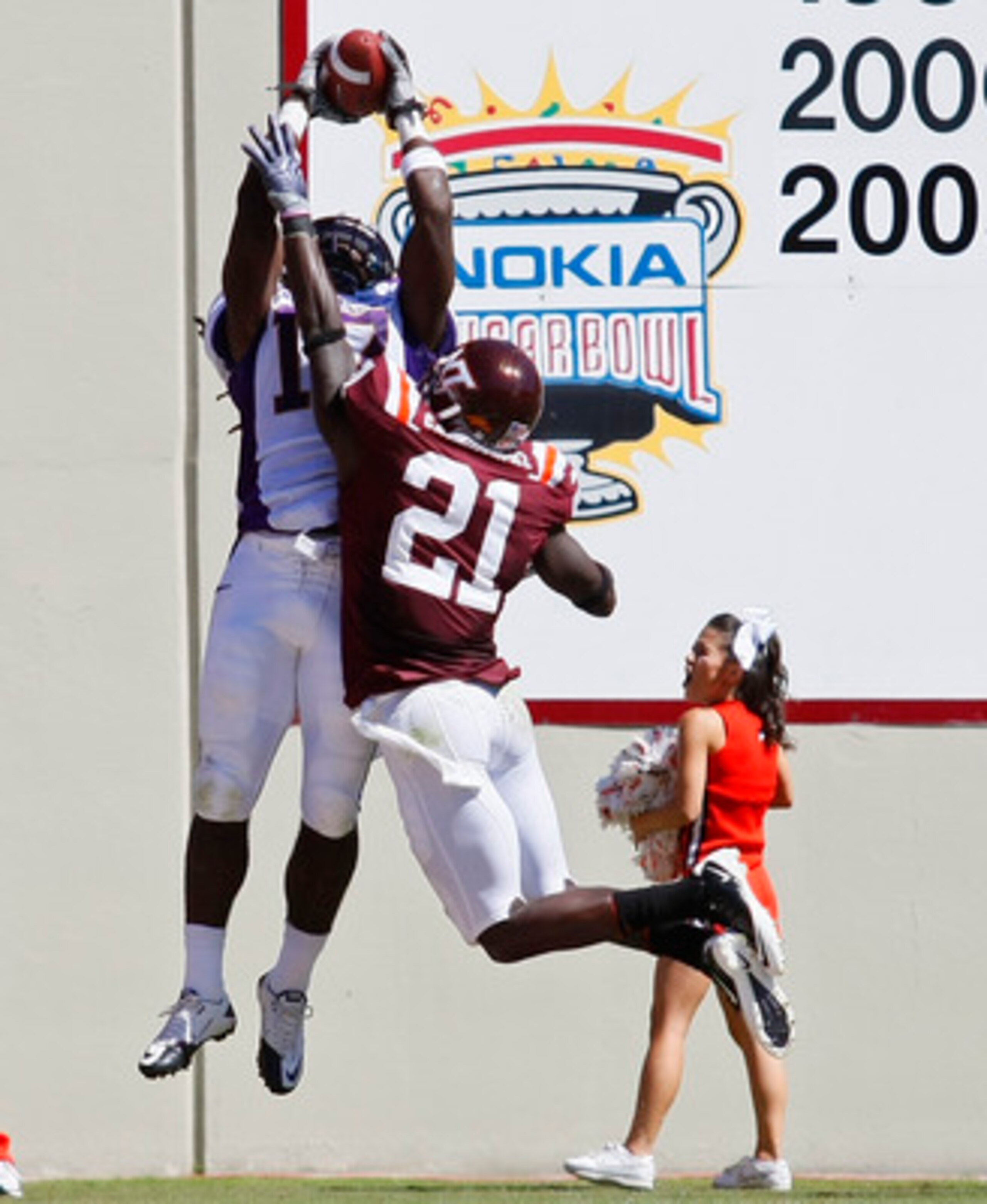 BLACKSBURG, VA - SEPTEMBER 18:  Wide receiver Dwayne Harris #17 of the East Carolina Pirates leaps to catch a pass for a touchdown over cornerback Rashad Carmichael #21 of the Virginia Tech Hokies at Lane Stadium on September 18, 2010 in Blacksburg, Virgi
