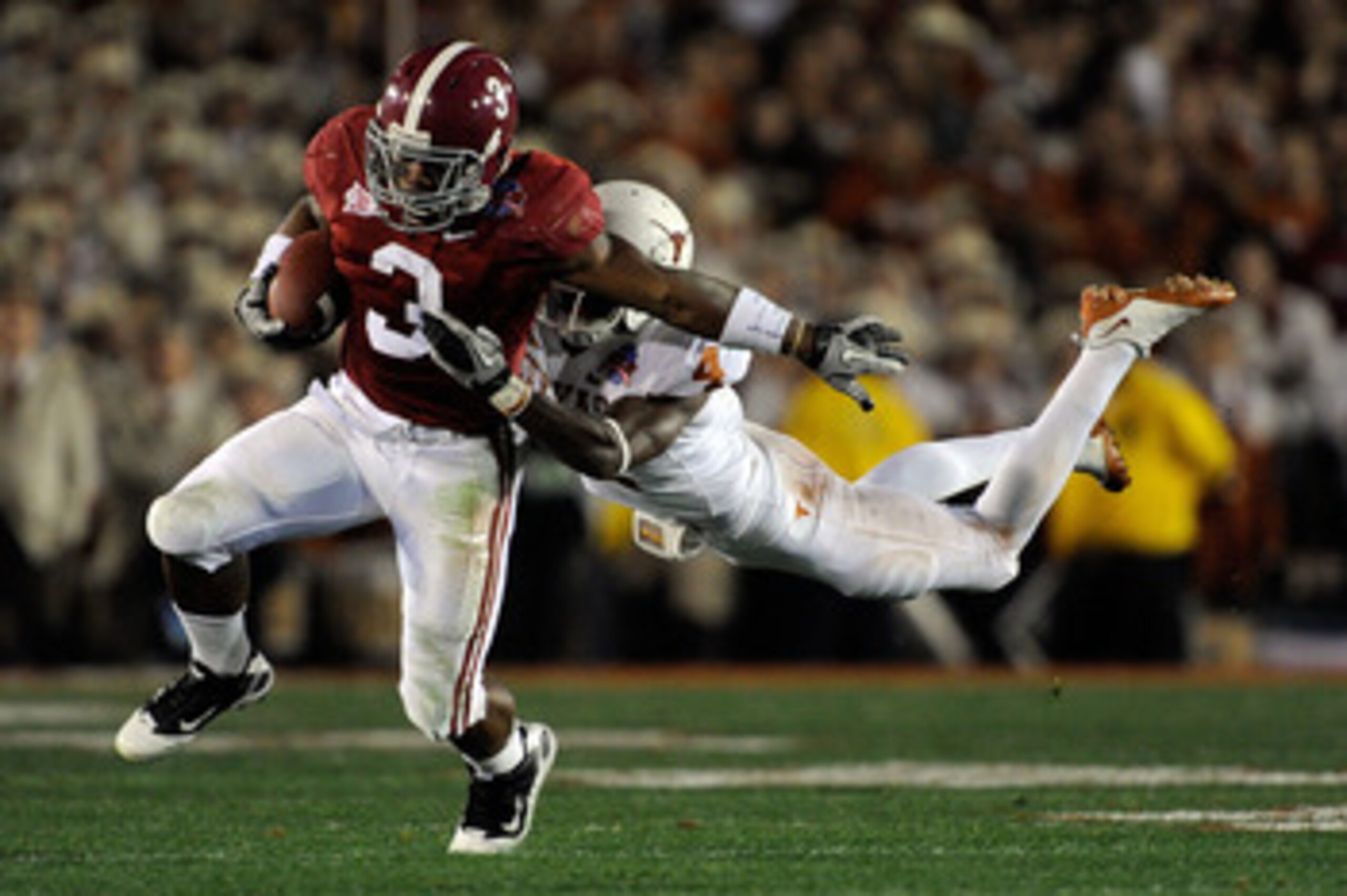 PASADENA, CA - JANUARY 07:  Running back Trent Richardson #3 of the Alabama Crimson Tide runs for an 11-yard gain after a catch as cornerback Aaron Williams #4 of the Texas Longhorns tackles him in the second quarter of the Citi BCS National Championship 