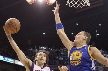 PHOENIX, AZ - FEBRUARY 10:  Steve Nash #13 of the Phoenix Suns lays up a shot past Andris Biedrins #15 of the Golden State Warriors during the NBA game at US Airways Center on February 10, 2011 in Phoenix, Arizona.  NOTE TO USER: User expressly acknowledg