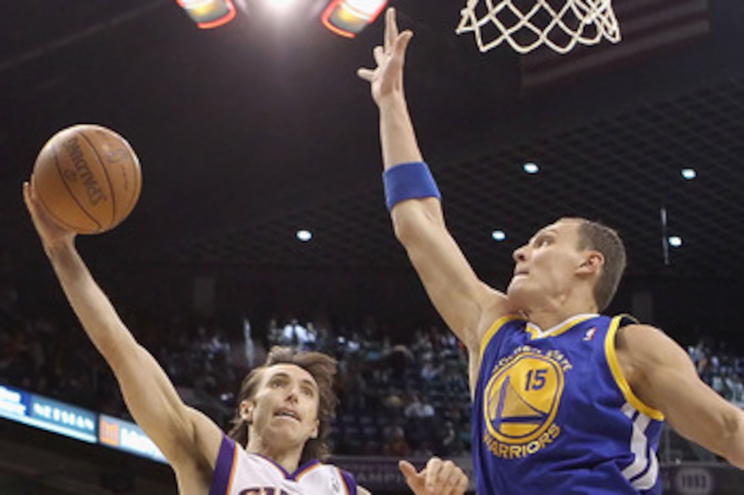 PHOENIX, AZ - FEBRUARY 10: Steve Nash #13 of the Phoenix Suns lays up a shot past Andris Biedrins #15 of the Golden State Warriors during the NBA game at US Airways Center on February 10, 2011 in Phoenix, Arizona. NOTE TO USER: User expressly acknowledg PHOENIX, AZ - FEBRUARY 10: Steve Nash #13 of the Phoenix Suns lays up a shot past Andris Biedrins #15 of the Golden State Warriors during the NBA game at US Airways Center on February 10, 2011 in Phoenix, Arizona. NOTE TO USER: User expressly acknowledg